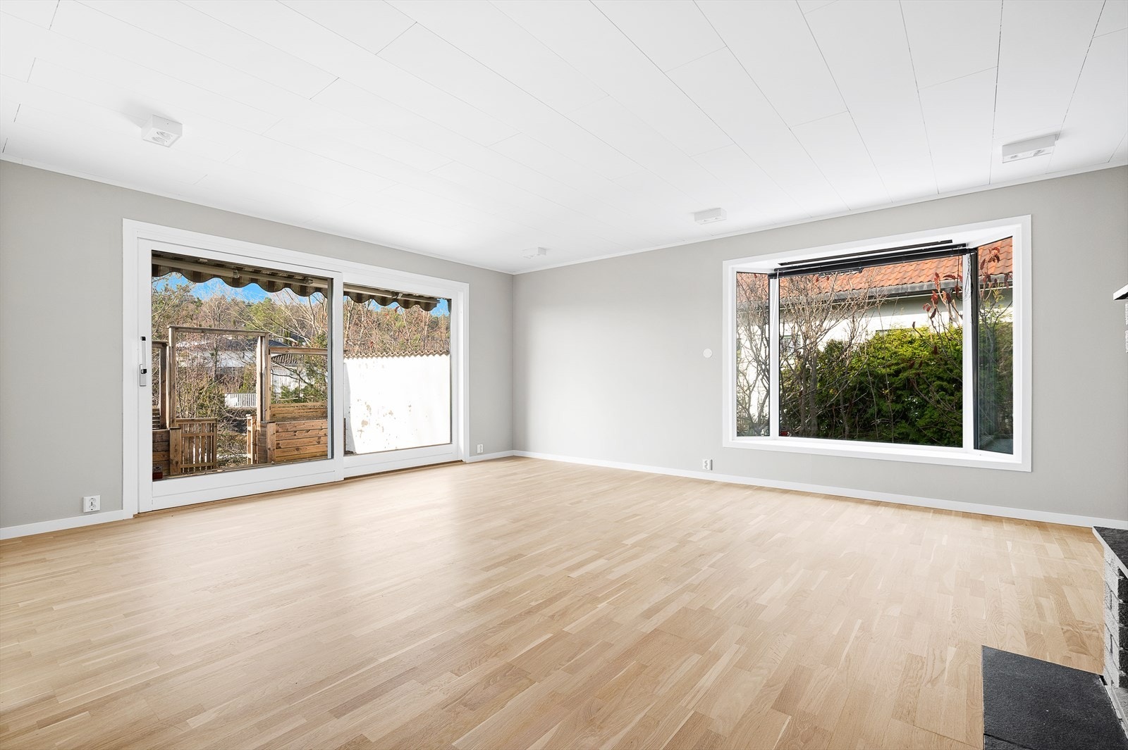 Store vindusflater og utgang til flere uteplasser rundt boligen Galleribilde