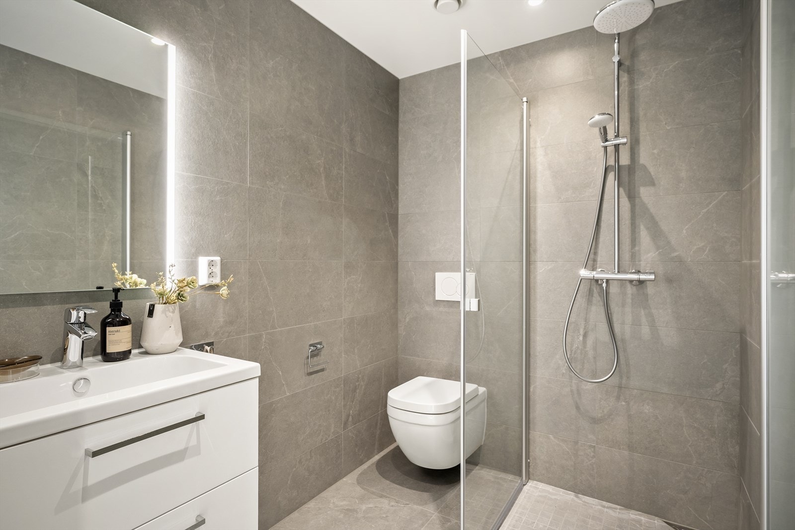 Badet i første etasje er helfliset med vegghengt toalett og dusjhjørne. Galleribilde