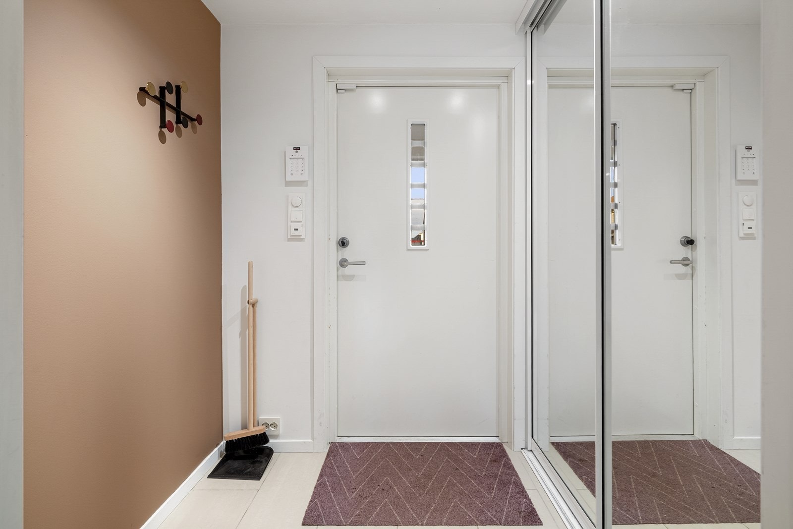 Praktisk flislagt vindfang med skyvedørsgarderobe Galleribilde