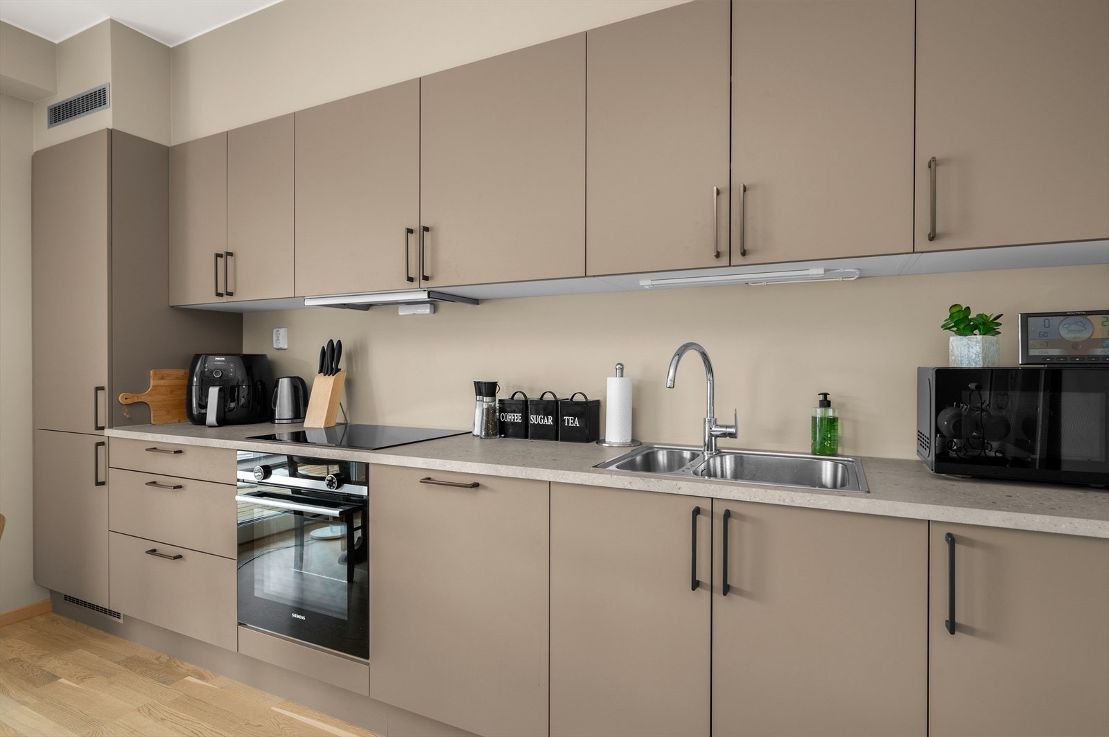 Leiligheten har et moderne kjøkken med integrerte hvitevarer som platetopp, oppvaskmaskin, stekovn, kjøleskap og frys. Galleribilde