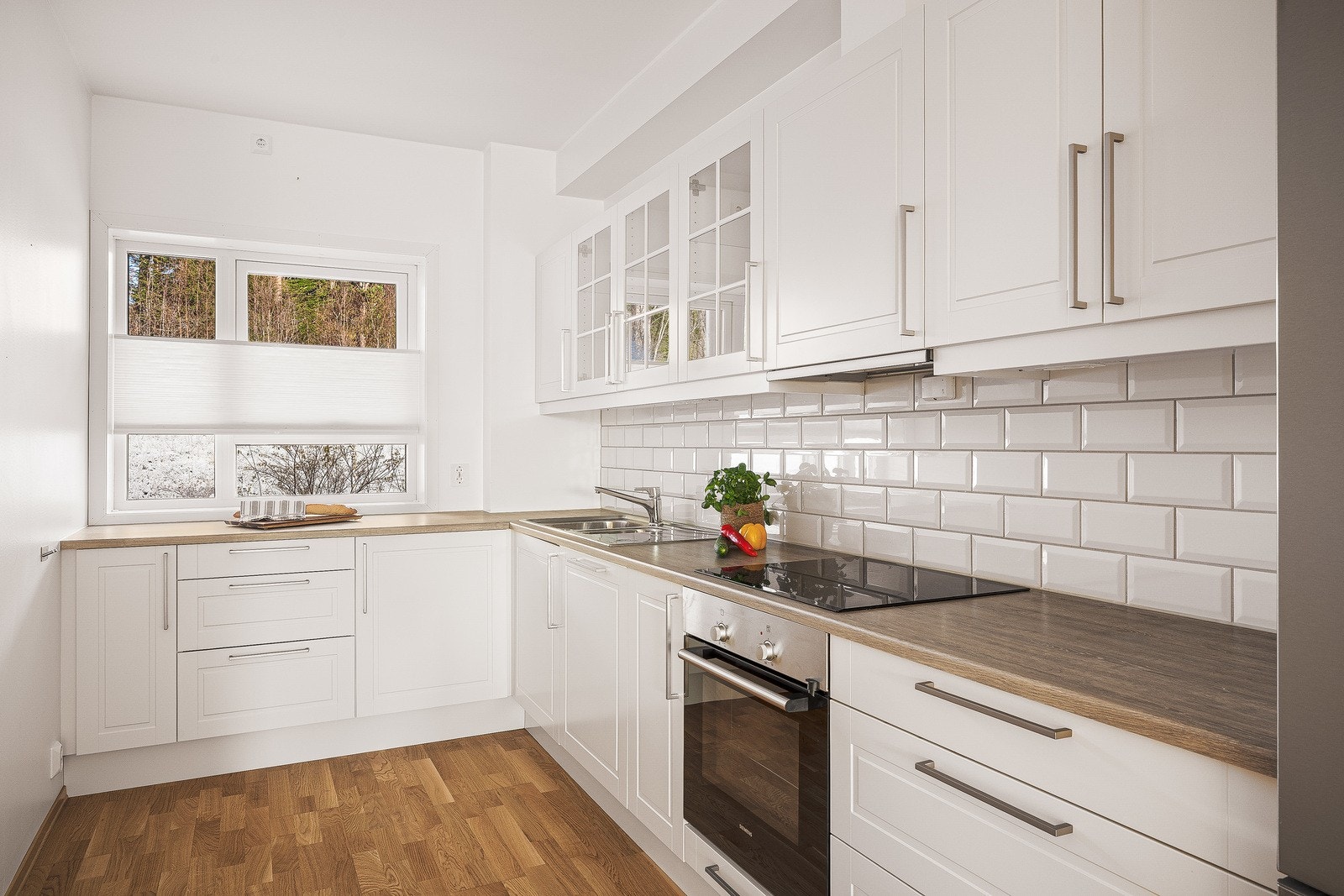 Kjøkkeninnredningen er av klassisk utforming med hvite profilerte fronter og benkeplate av laminat. Galleribilde