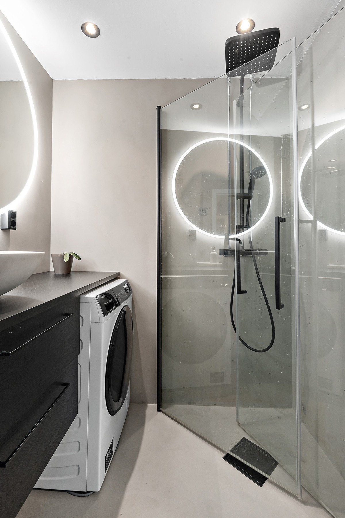 Badet har moderne overflater med mikrosement på både gulv og vegger. Det er innredet med servant med ettgreps armatur og stort speil med integrert belysning. Galleribilde