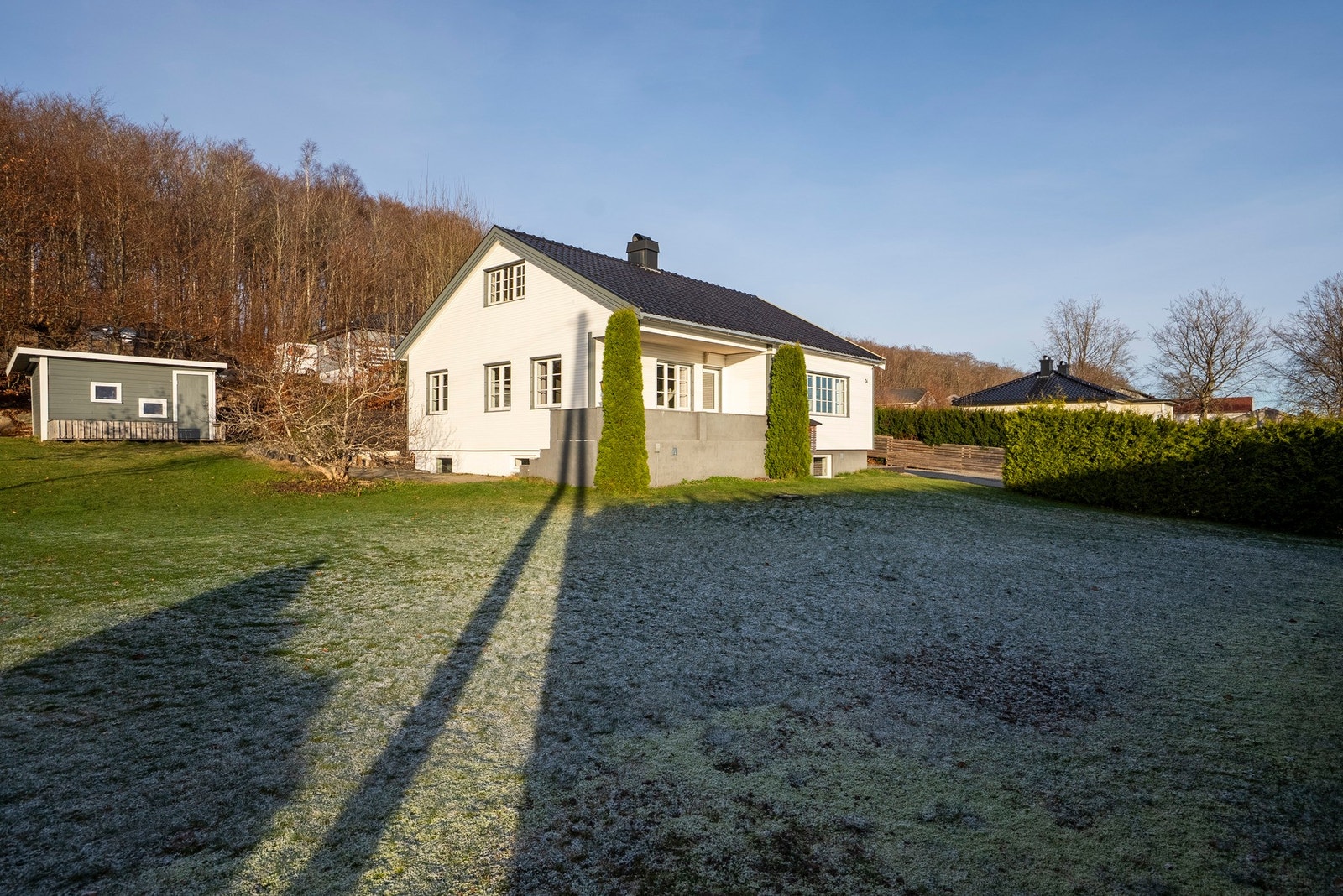 En koselig enebolig med stelte uteområder og en skjermet tomt omkranset av hekk - perfekt for både lek og avslapning Galleribilde