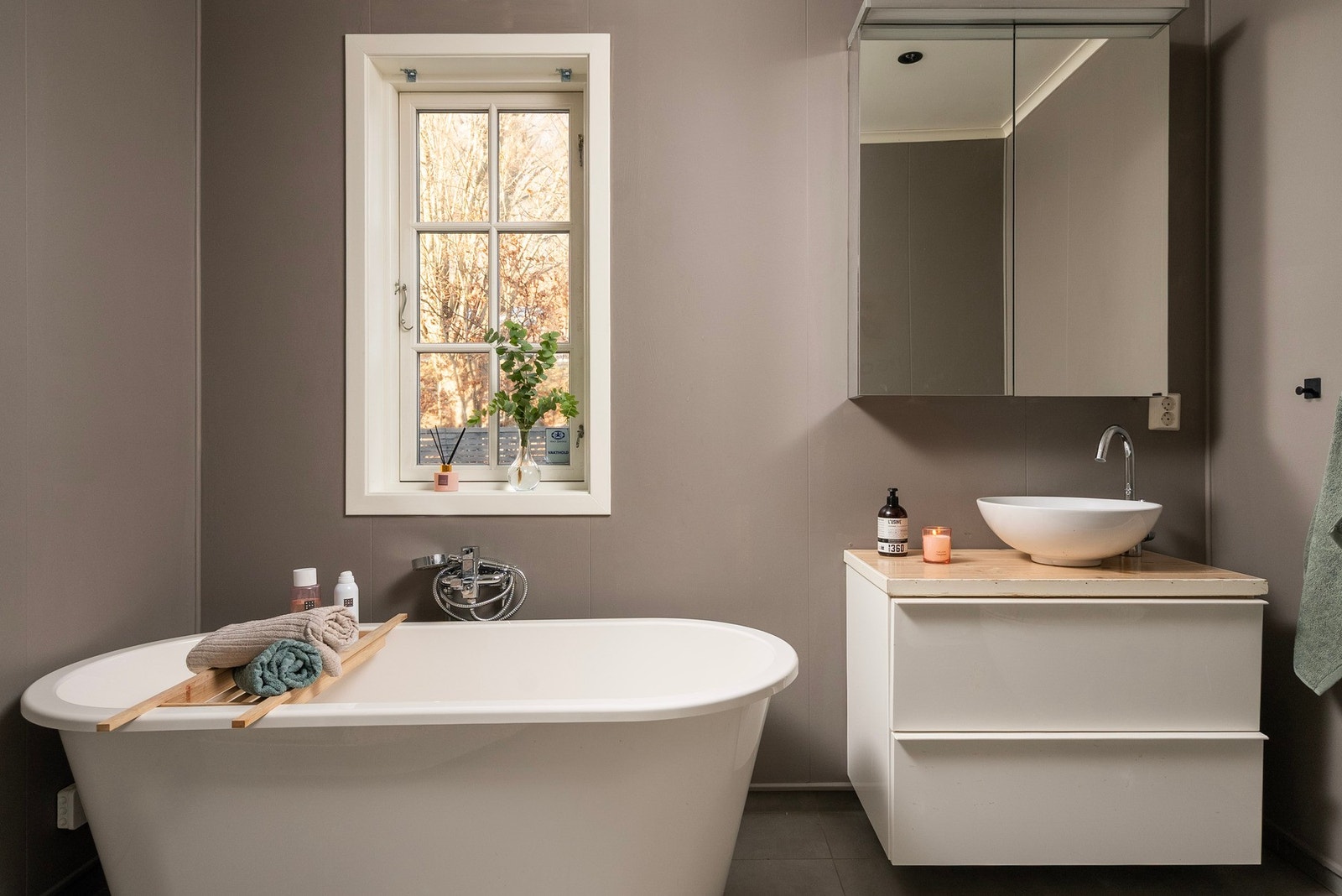 Badet i 1. etasje ble oppgradert rundt 2015 og har moderne jordtoner som harmonerer med det flislagte gulvet Galleribilde