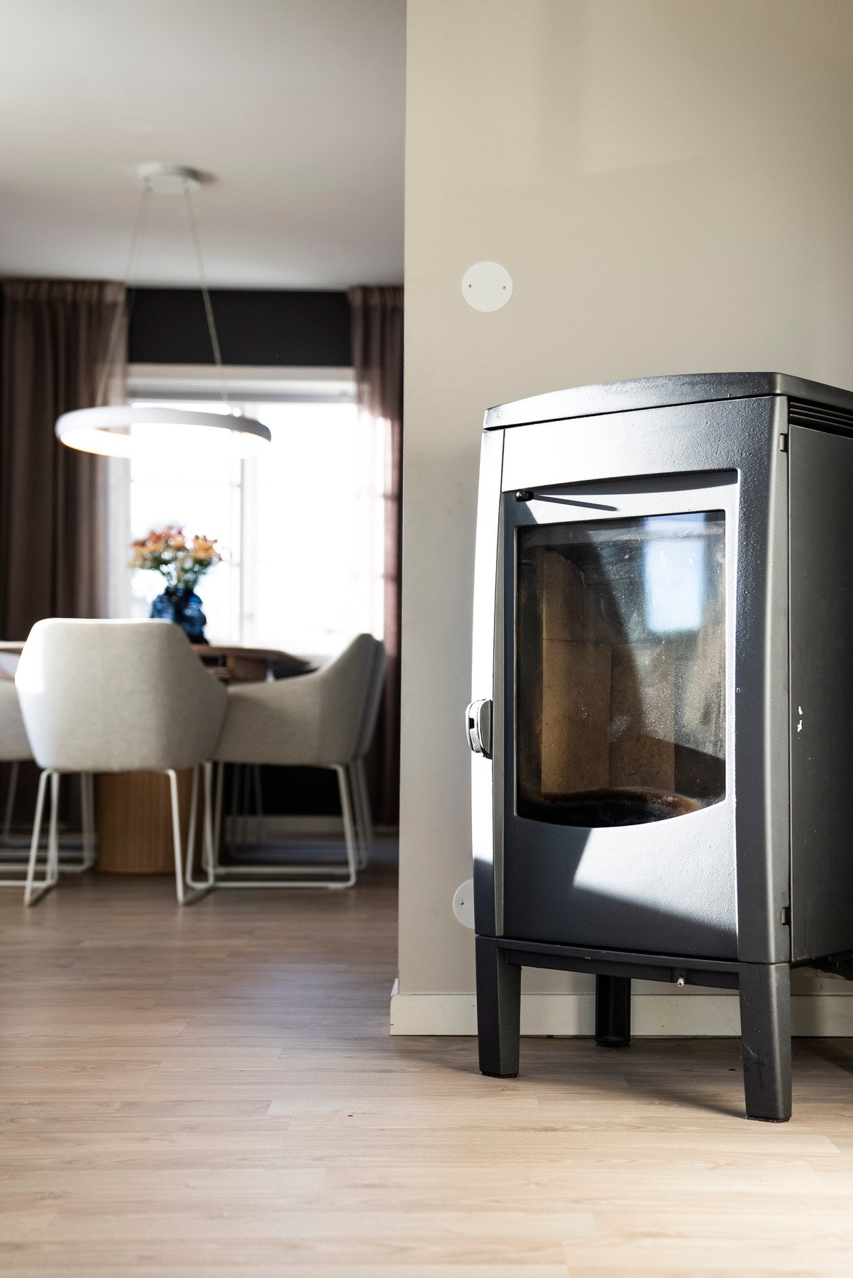 Peisovnen skaper både lun varme og et koselig blikkfang, samtidig som den bidrar til å dele stuen i naturlige soner uten å bryte den åpne romfølelsen Galleribilde