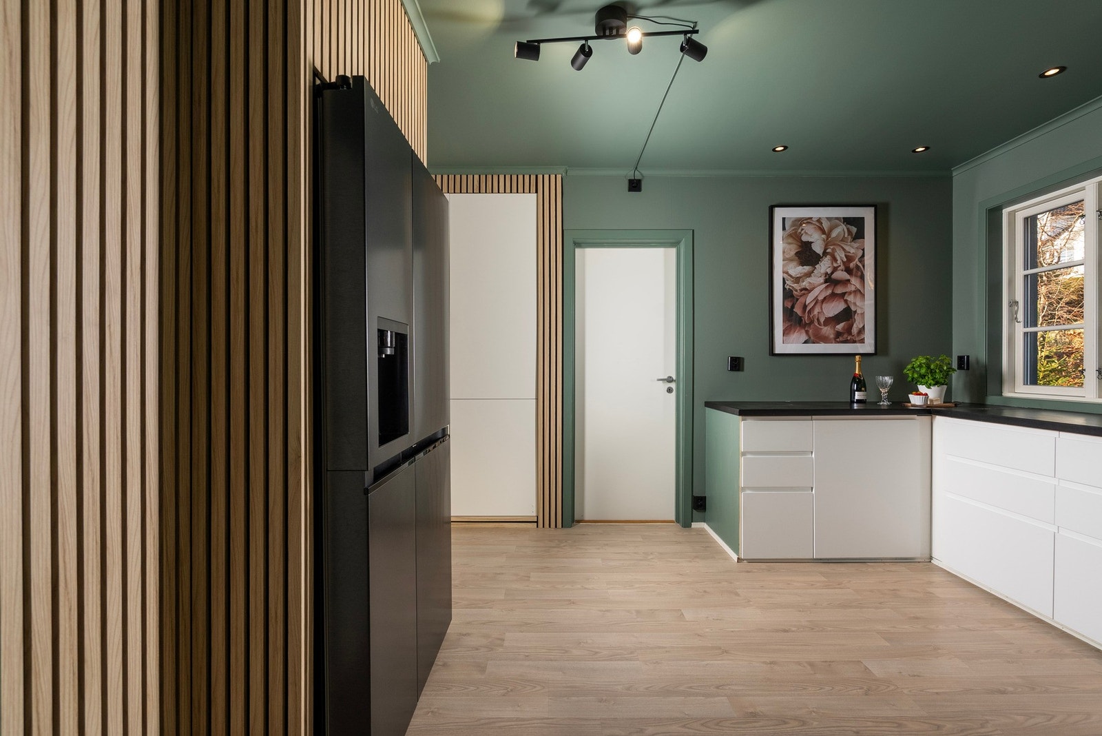 Her har du rikelig plass i innredningen med glatte fronter og benkeplate av heltre - Spotter og downlights i taket sørger for godt arbeidslys for kokken Galleribilde