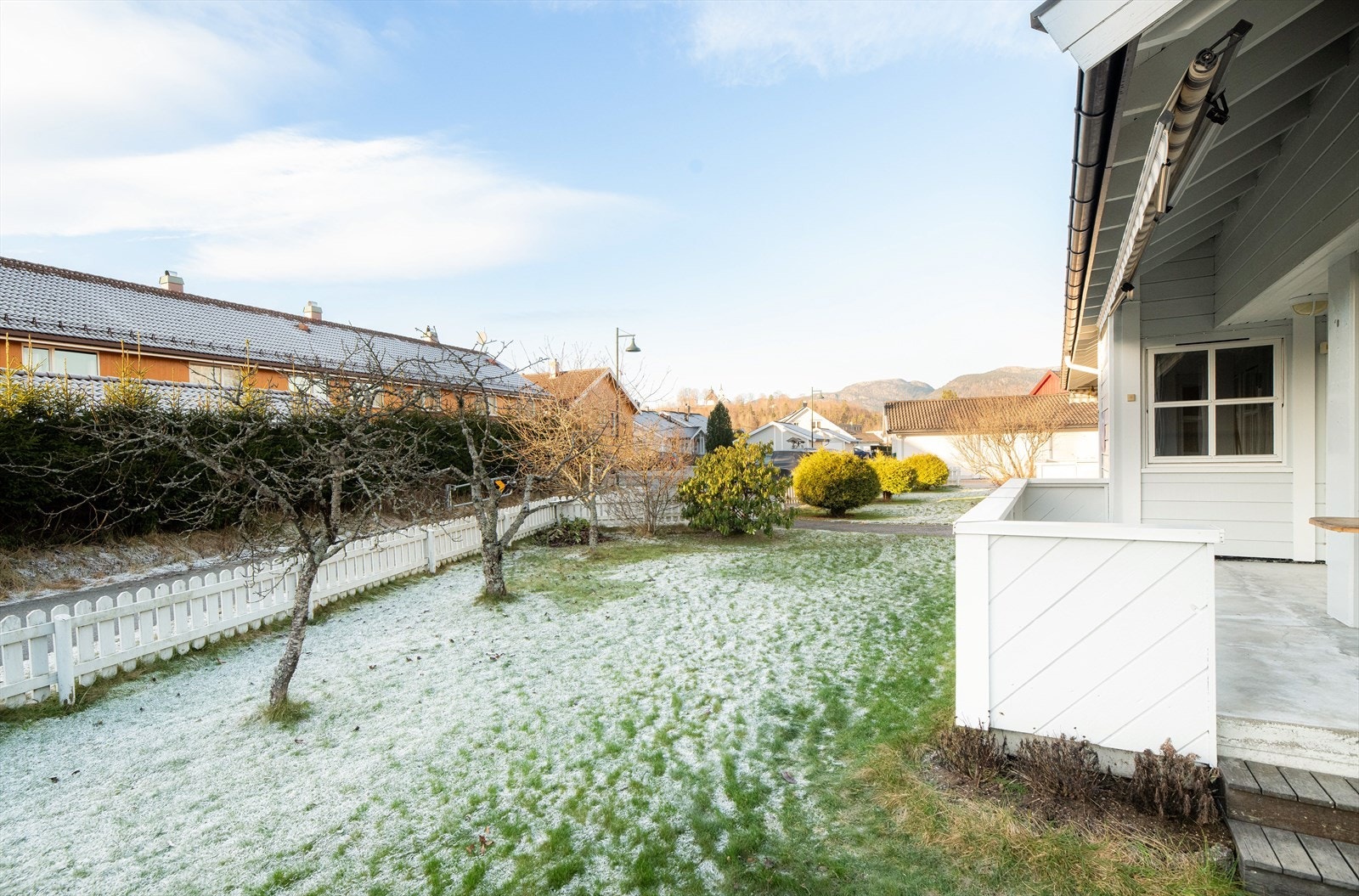 Det er trapp fra veranda og ned til hagen som er pent opparbeidet med plenareal, små trær og diverse prydbusker. Galleribilde