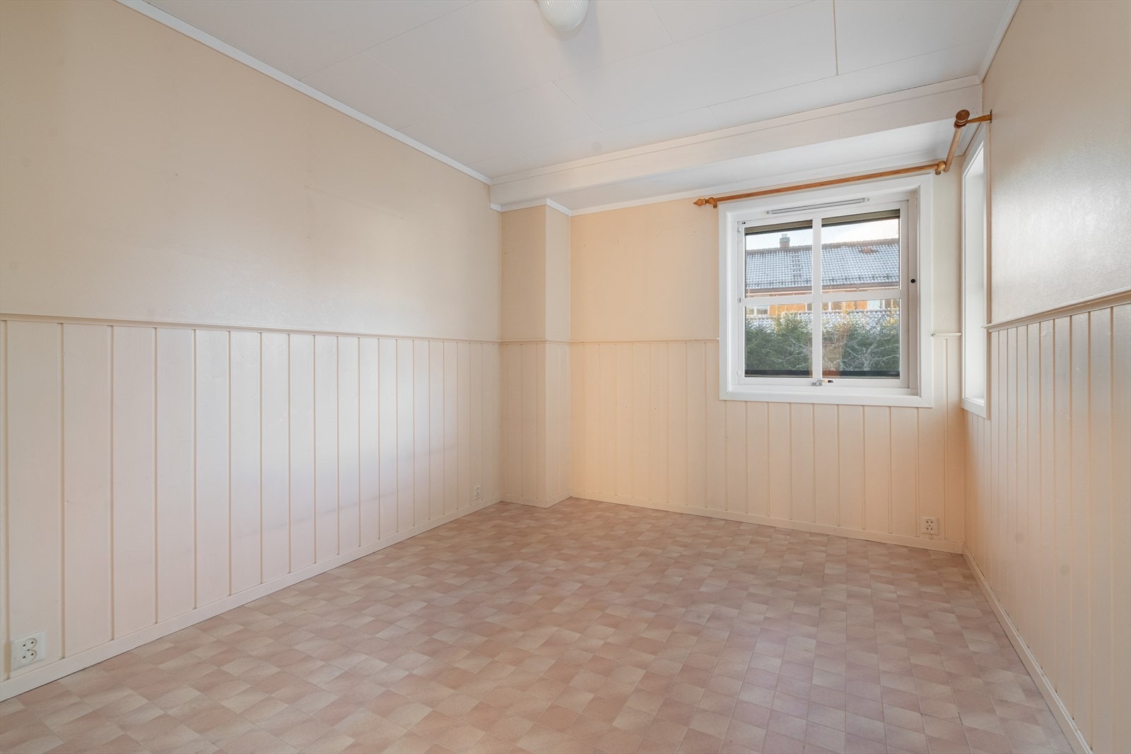 Hovedsoverommet ved kjøkkenet har lyse overflater med belegg på gulvet og malt brystning på veggene. Galleribilde