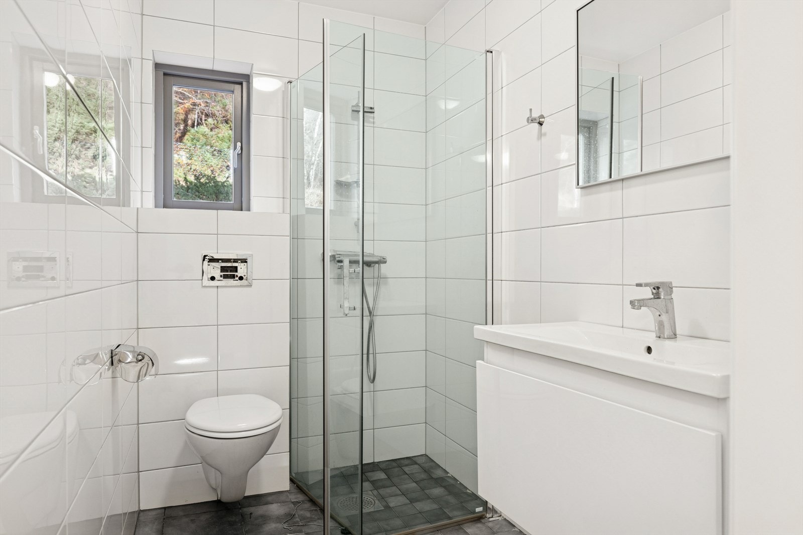 Baderommene har badersomsesksjon med vask, speil, dusjhjørne og vegghengt toalett. Galleribilde