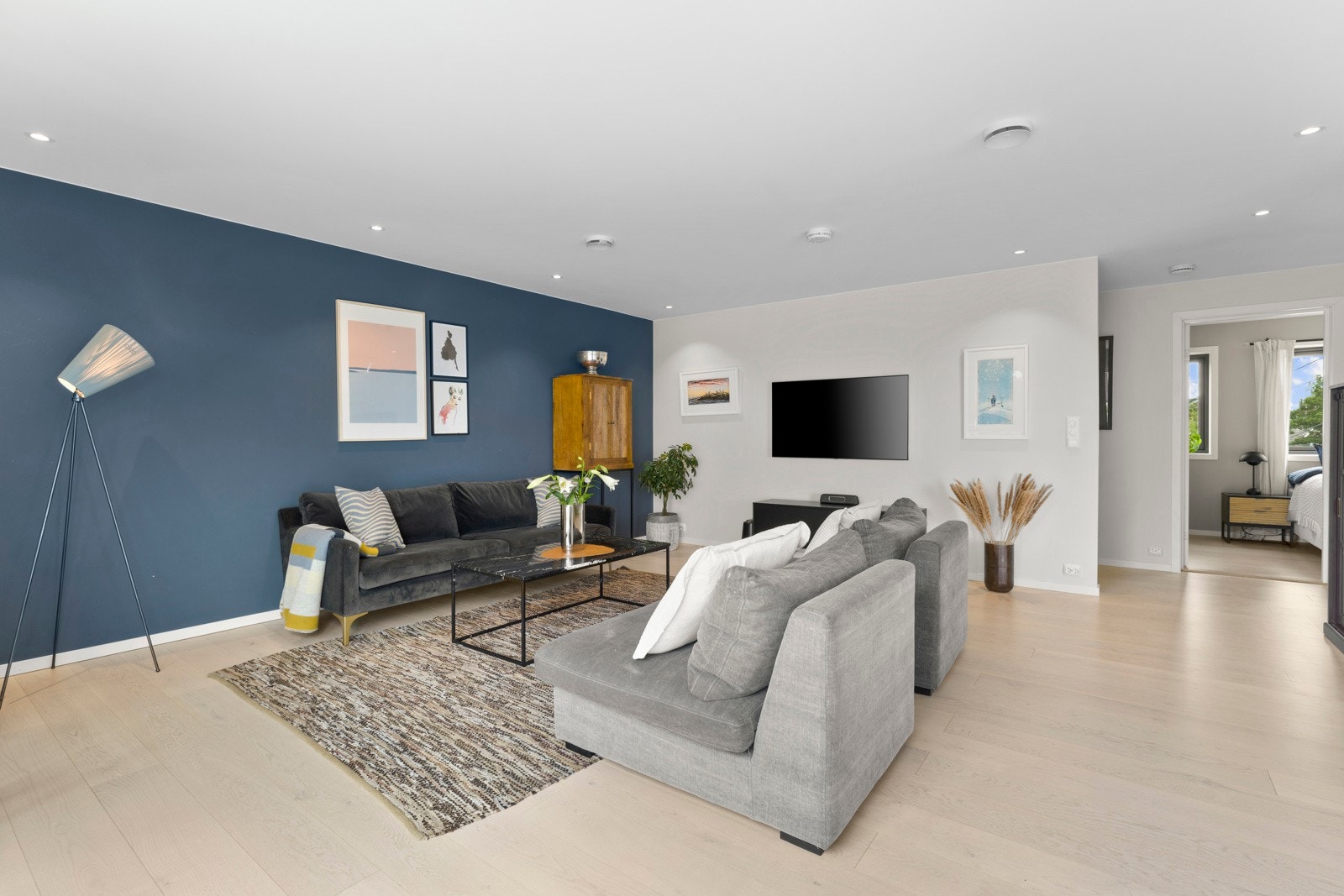 Veggene er holdt i lyse fargetoner, kombinert med en kontrastvegg i dyp blå, som sammen med ettstavs parketten skaper en innbydende atmosfære. Galleribilde