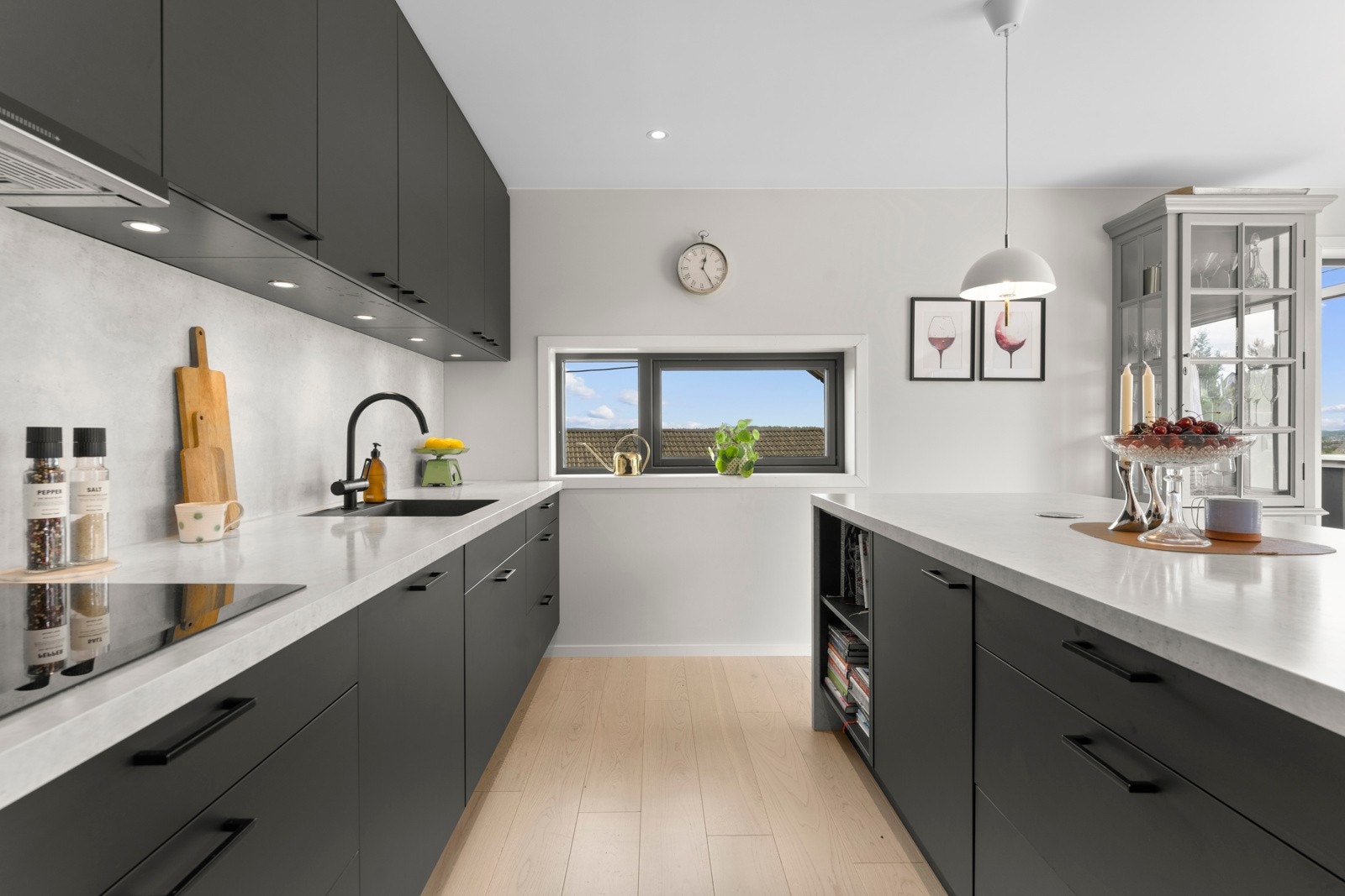 Det er praktisk belysning under overskapene og kjøkkenplate på vegg mellom overskap og kjøkkenbenk gir et stilfullt preg. Galleribilde