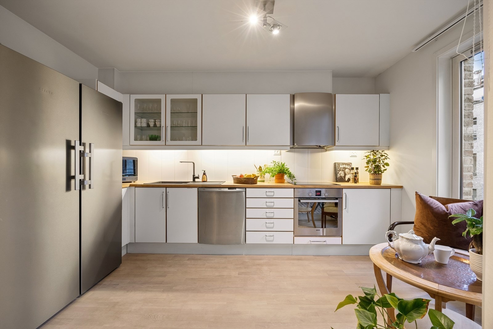 Stort og flott Noremakjøkken. Benkeplate i eik heltre med nedfelt vask. Fliser mellom benk og overskap med downlights. Kjøkkenet er utstyrt med kjøl/fryseskap, oppvaskmaskin, platetopp, stekeovn og vannstoppsystem. Avtrekk via mekanisk ventilasjon. Galleribilde