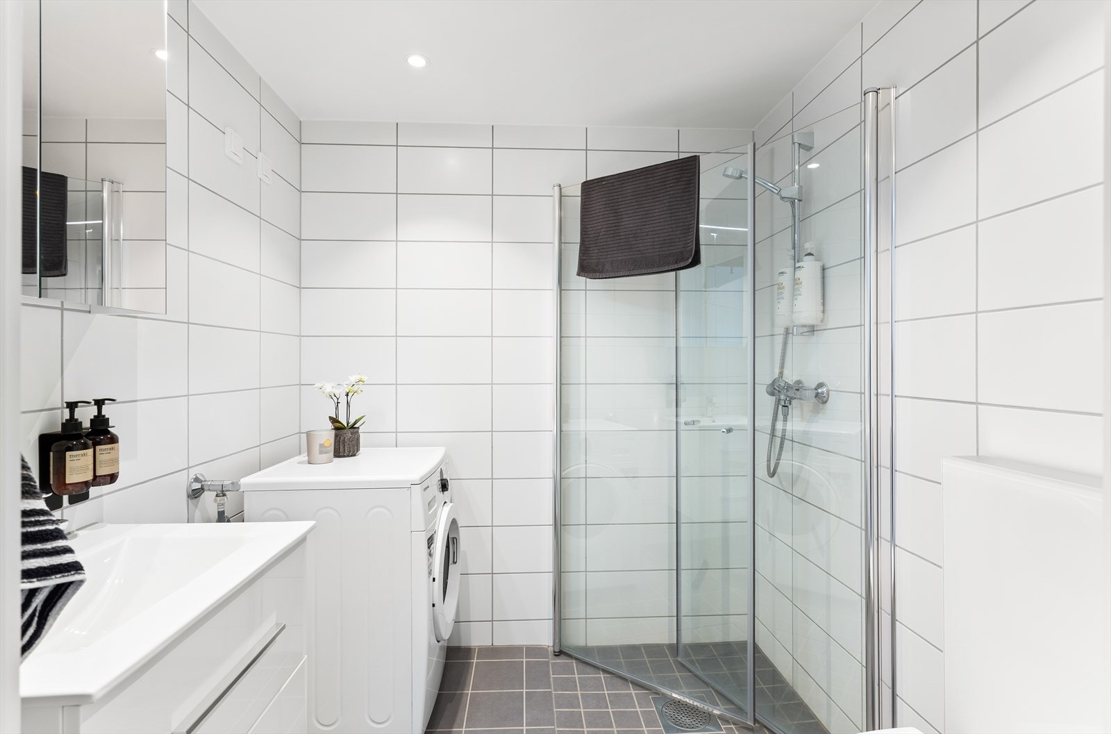 Delikat bad med flislagte overflater, gulvvarme og downlights i himling. Galleribilde