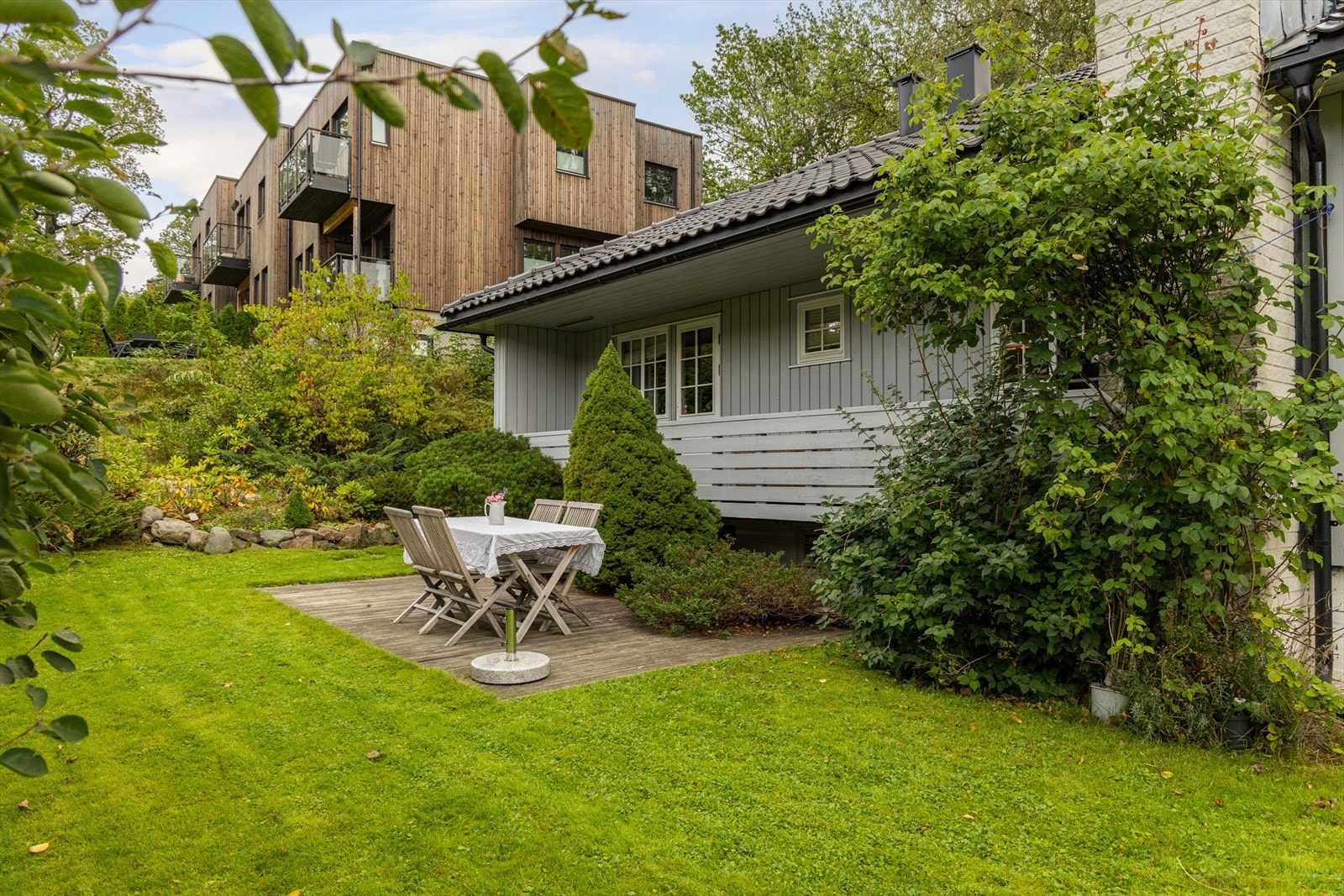 Hagen er pent opparbeidet med gressplen, plattinger, heller og beplantning. Galleribilde