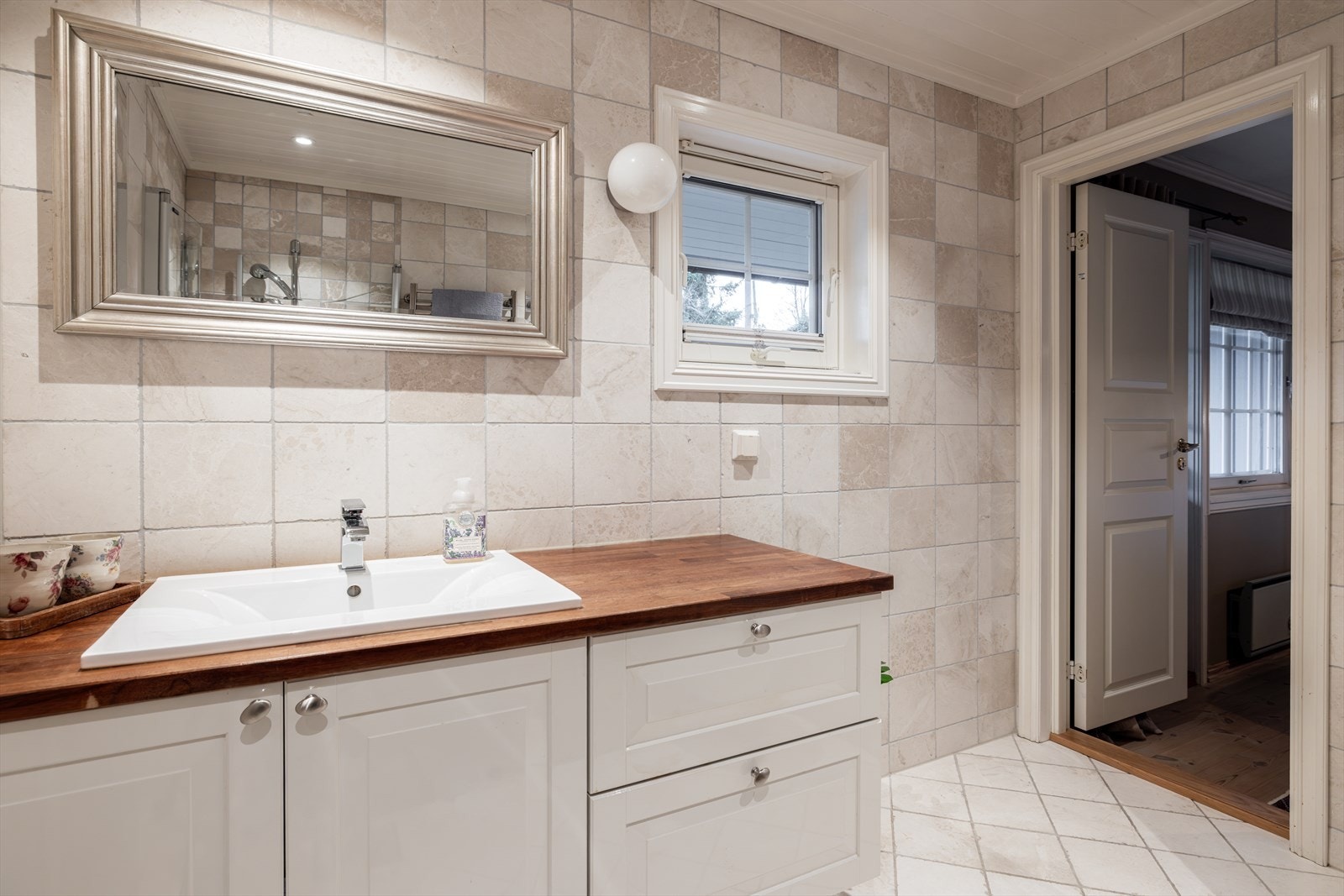 Badet er innredet med nedfelt servant, veggmontert toalett og dusjvegger/hjørne. Galleribilde