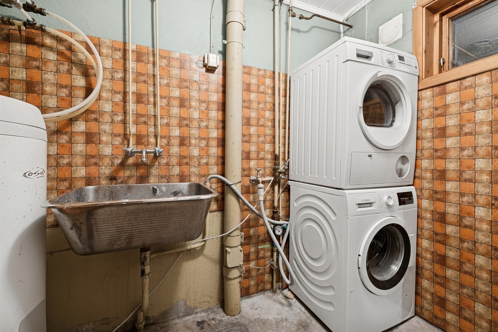 I underetasjen er det et praktisk, separat vaskerom. Rommet er innredet med en utslagsvask i rustfritt stål, en 200-liters varmtvannsbereder og har opplegg for vaskemaskin og tørketrommel. Galleribilde