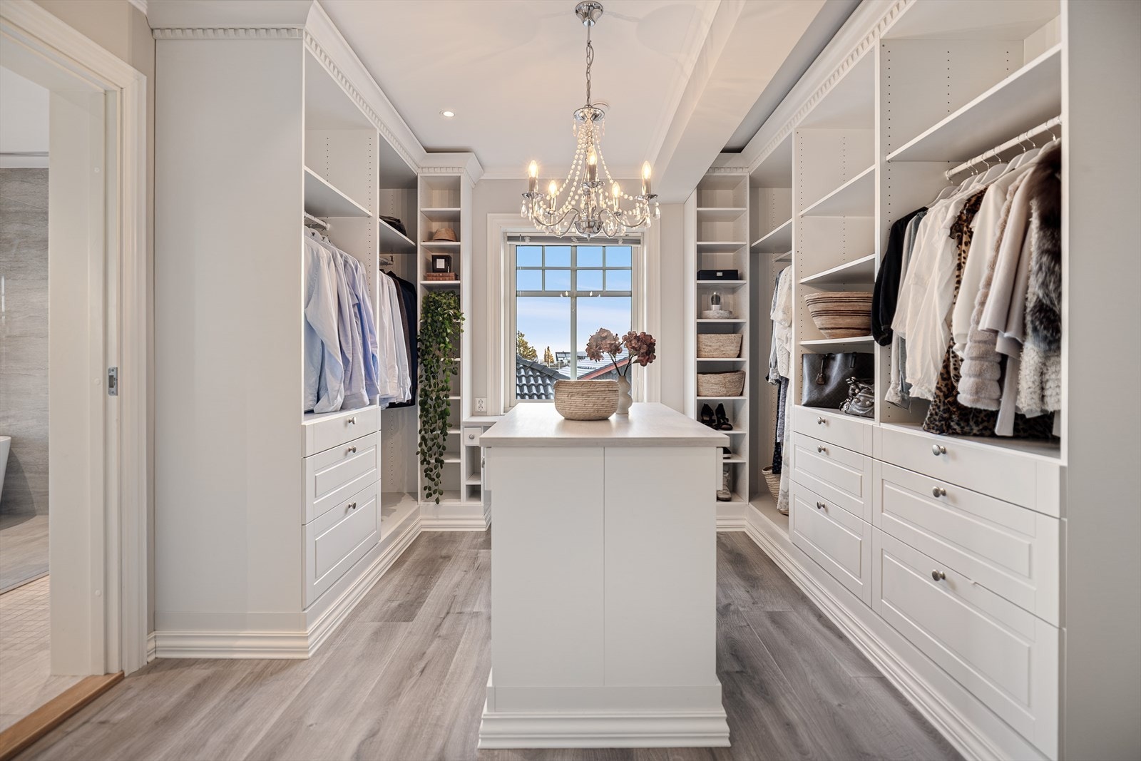 Walk-in closetet er innredet med et imponerende utvalg av hyller, skuffer og opphengsløsninger som gir optimal orden og oversikt. Her har du rikelig med plass til både klær, sko og tilbehør Galleribilde