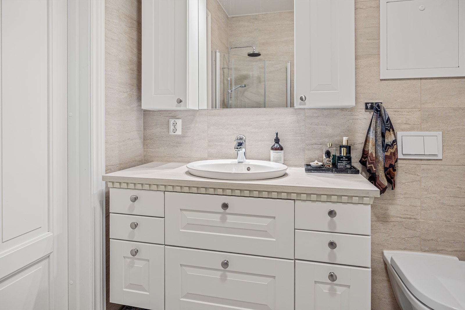 Bad/vaskerommet i hybelen fremstår både lekkert,og svært praktisk. Rommet har fliser på gulv med elektriske varmekabler, som gir en behagelig og lun varme. Veggene er også flislagt, og taket har malte plater som gir et rent og helhetlig uttrykk. Galleribilde