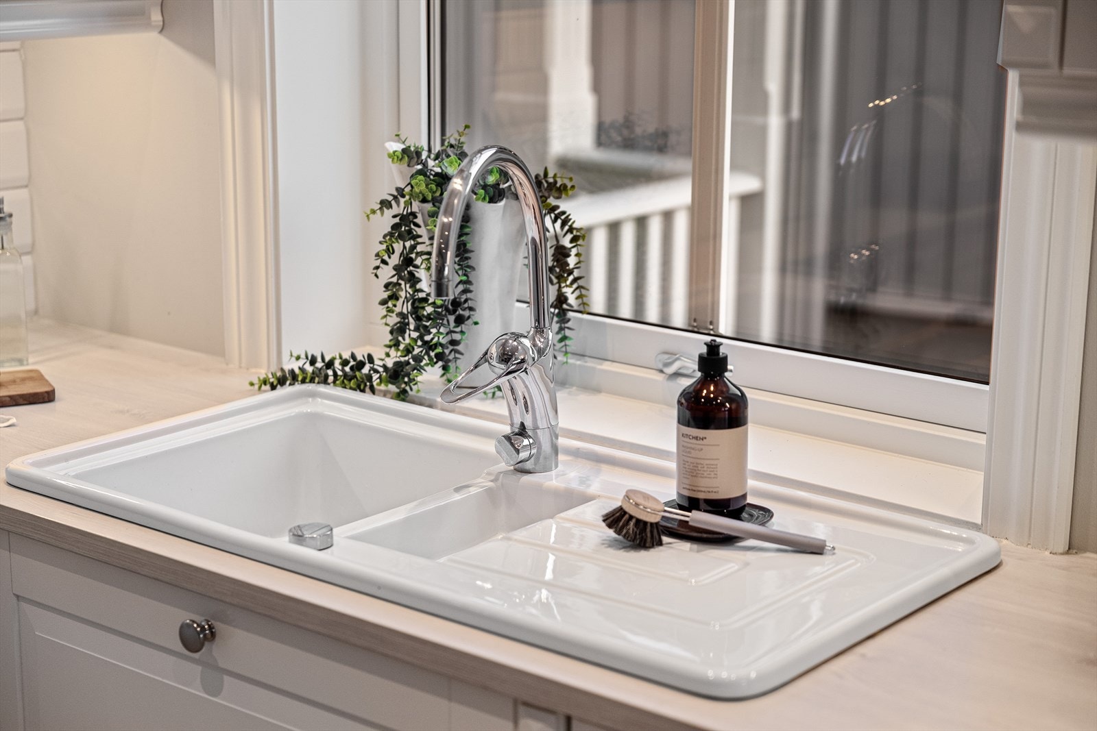 Benkeplaten i slitesterk laminat står i nydelig kontrast til den hvite nedfelte oppvaskkummen - en detalj som både ser eksklusiv ut og tåler daglig bruk med glans. Galleribilde