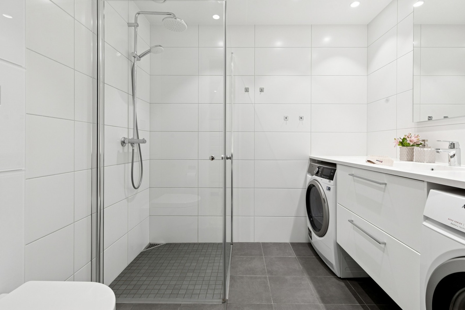 Begge badene er flislagte, innredet med downlights, gulvvarme og vegghengt toalett Galleribilde