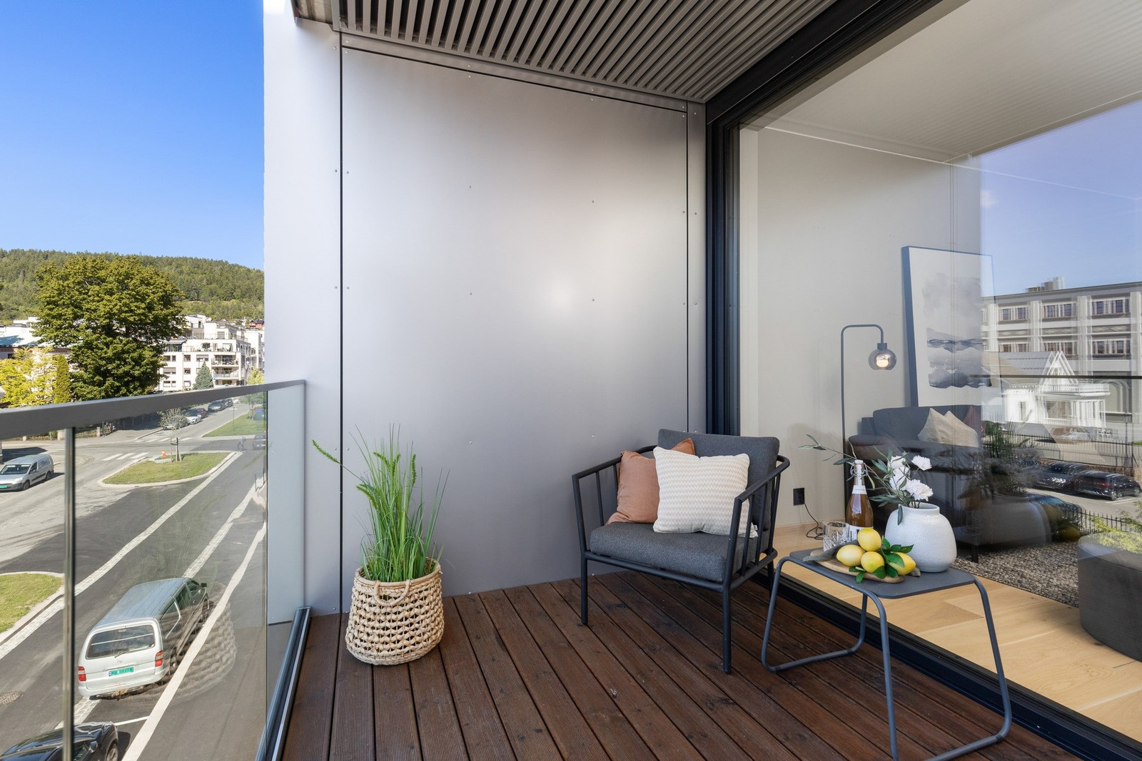 Den ene balkongen har overbygg, brunbeiset gulv, panelvegg og glassrekkverk i front. Galleribilde