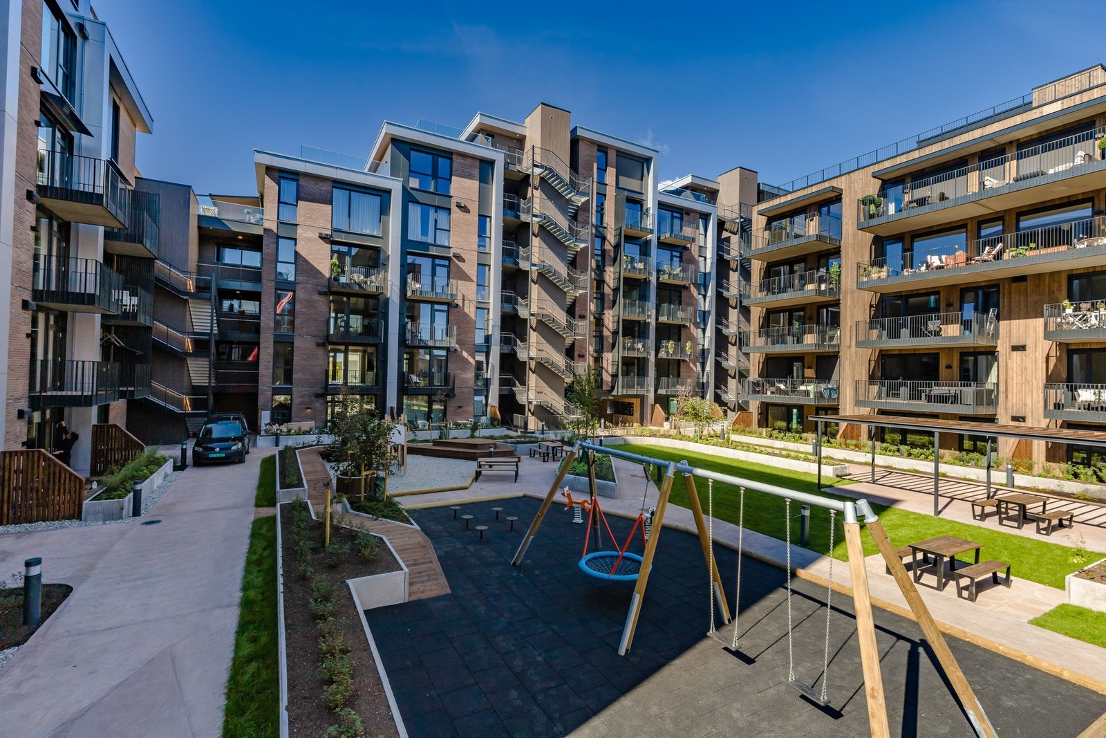Sittebenker er plassert rundt om, den ene under pergola, og barn i ulike aldre kan glede seg over moderne lekefasiliteter. Galleribilde
