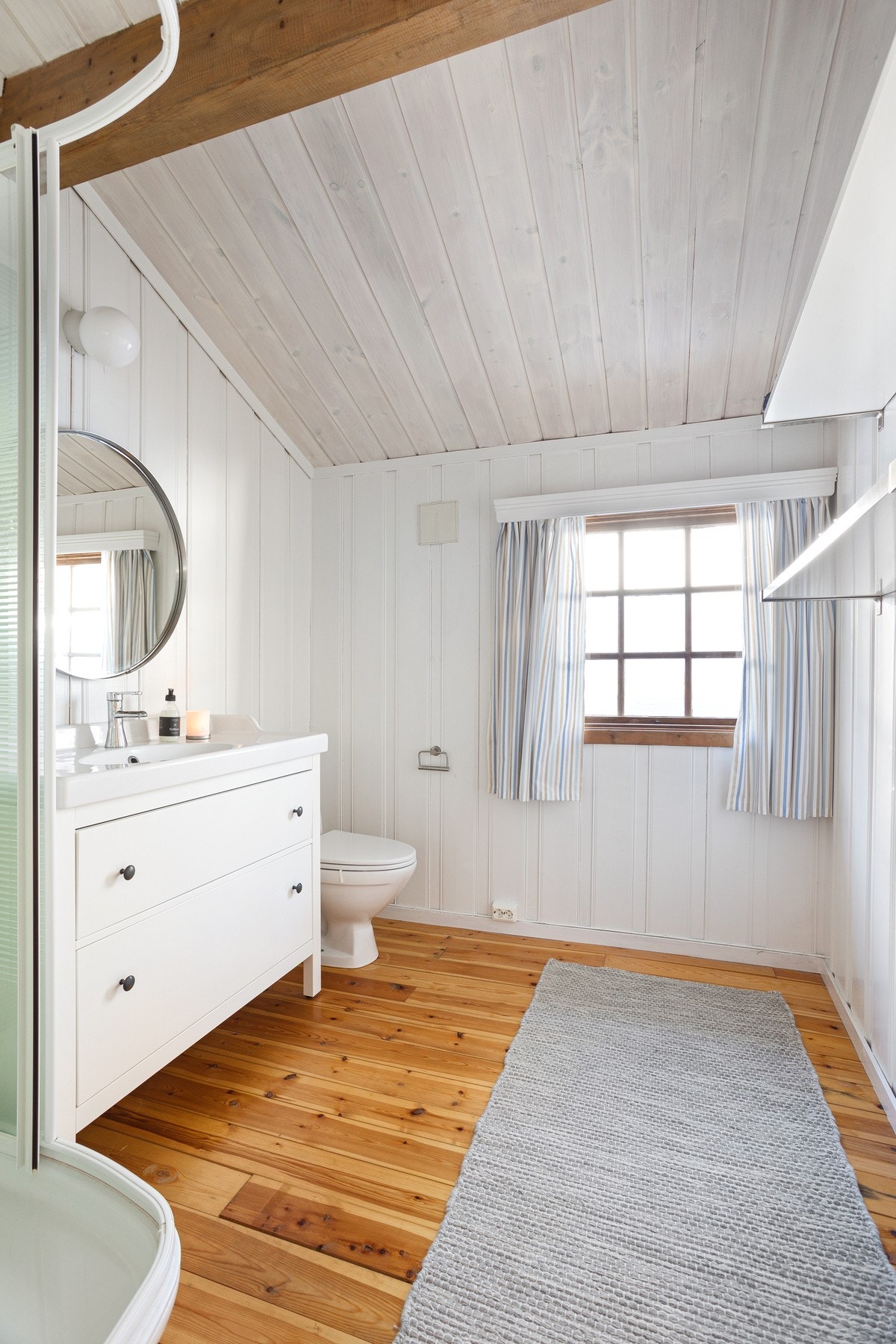 Romslig baderom med toalett, dusjkabinett og innredning med servant Galleribilde