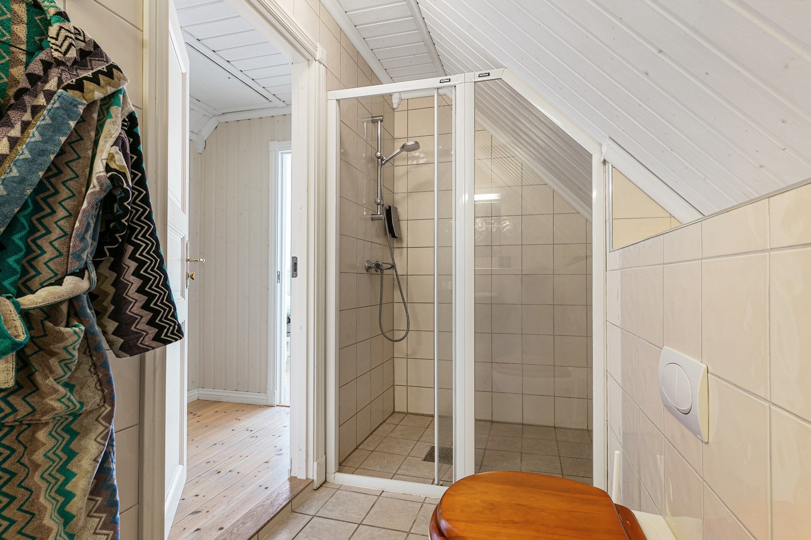 Bad i 2.etasje med dusjhjørne, vegghengt toalett og vask. Galleribilde