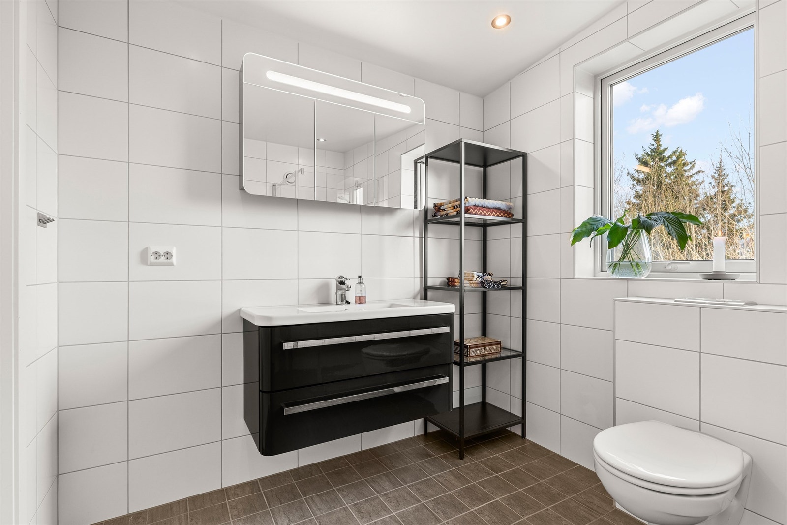 Rommet har vegghengt innredning, overskap med speil og vannbåren gulvvarme. Galleribilde