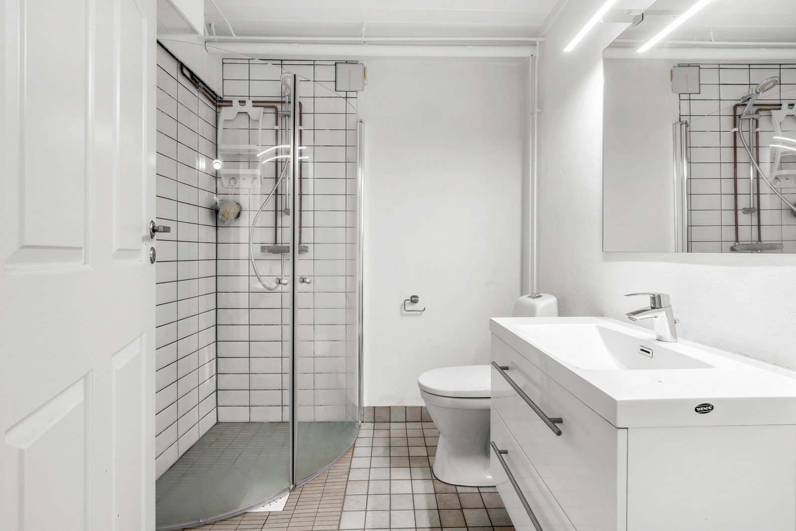 Baderommet består av servant med underskap, speil med overlys, toalett og dusjnisje med innfellbare glassdører. Galleribilde