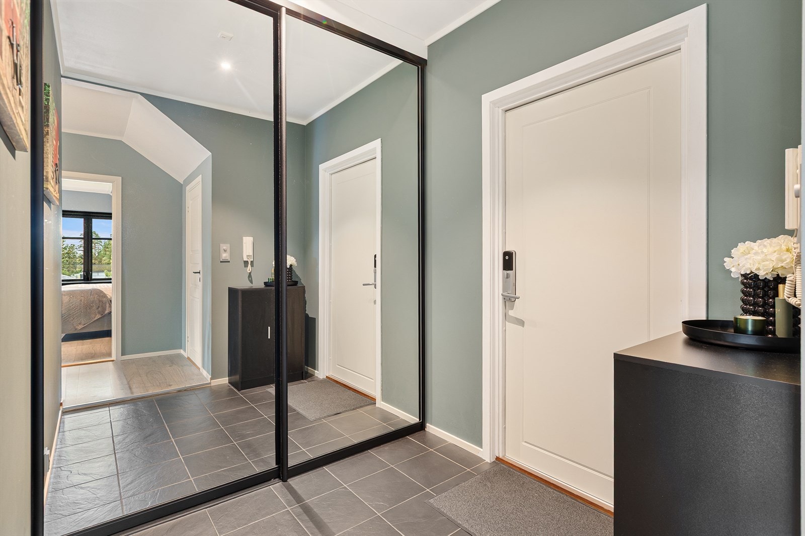 Vi starter turen i entréen, som har en praktisk skyvedørsgarderobe for oppbevaring. Galleribilde