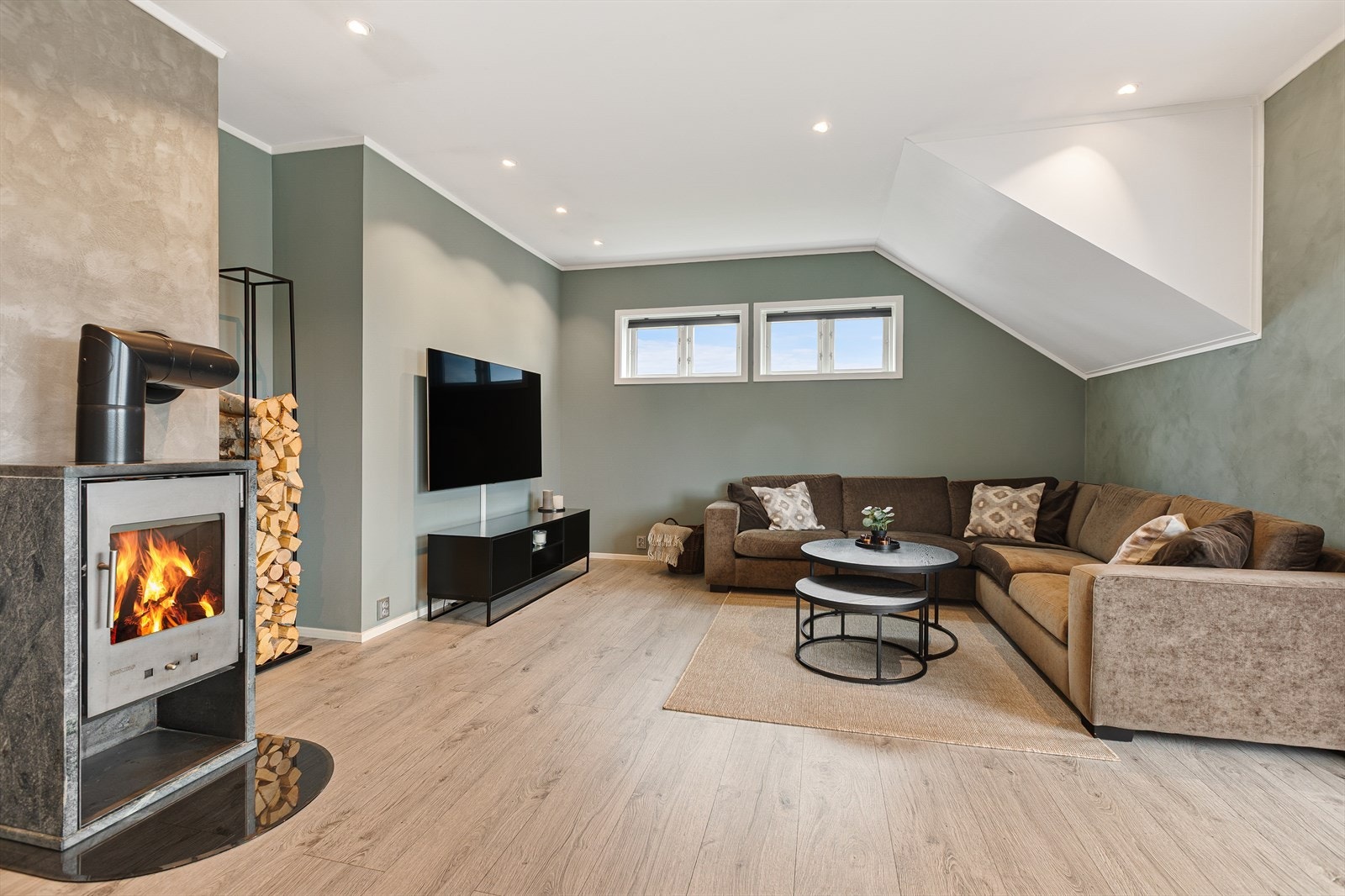 Stuen varmes effektivt opp av en varmepumpe fra 2020, supplert av vedovnen. Galleribilde