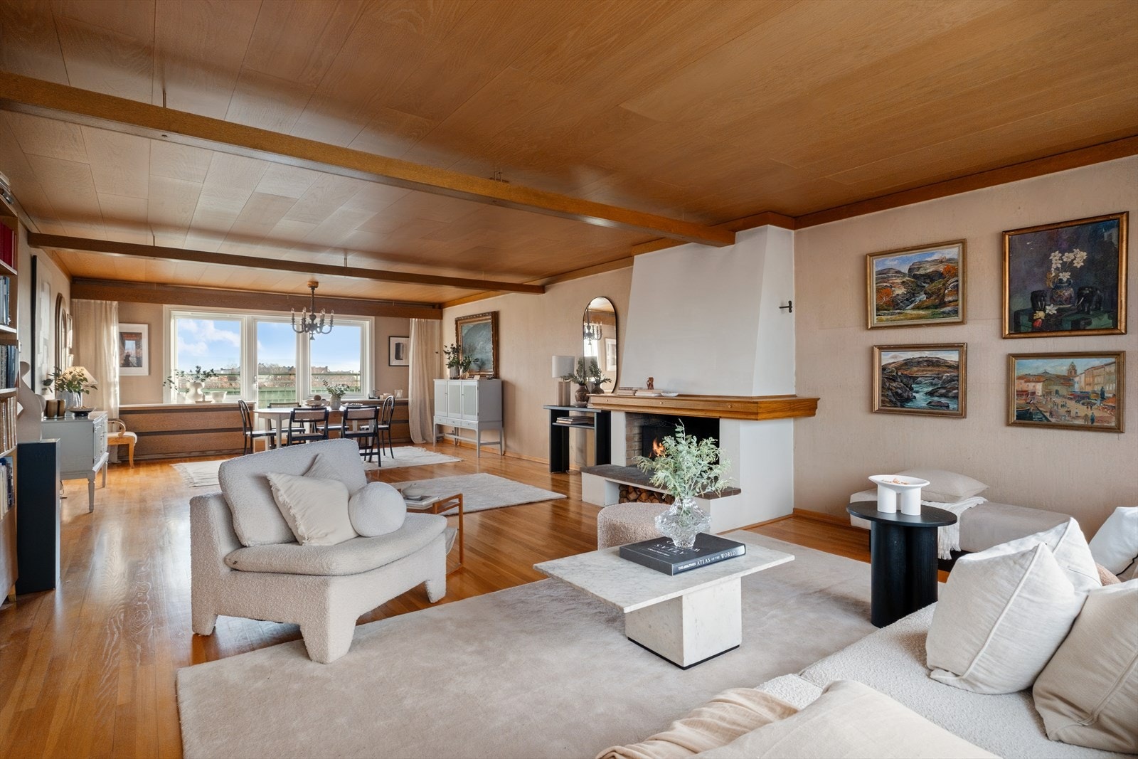 Leiligheten har en stor og åpen stue med peis plassert sentralt i rommet. Galleribilde