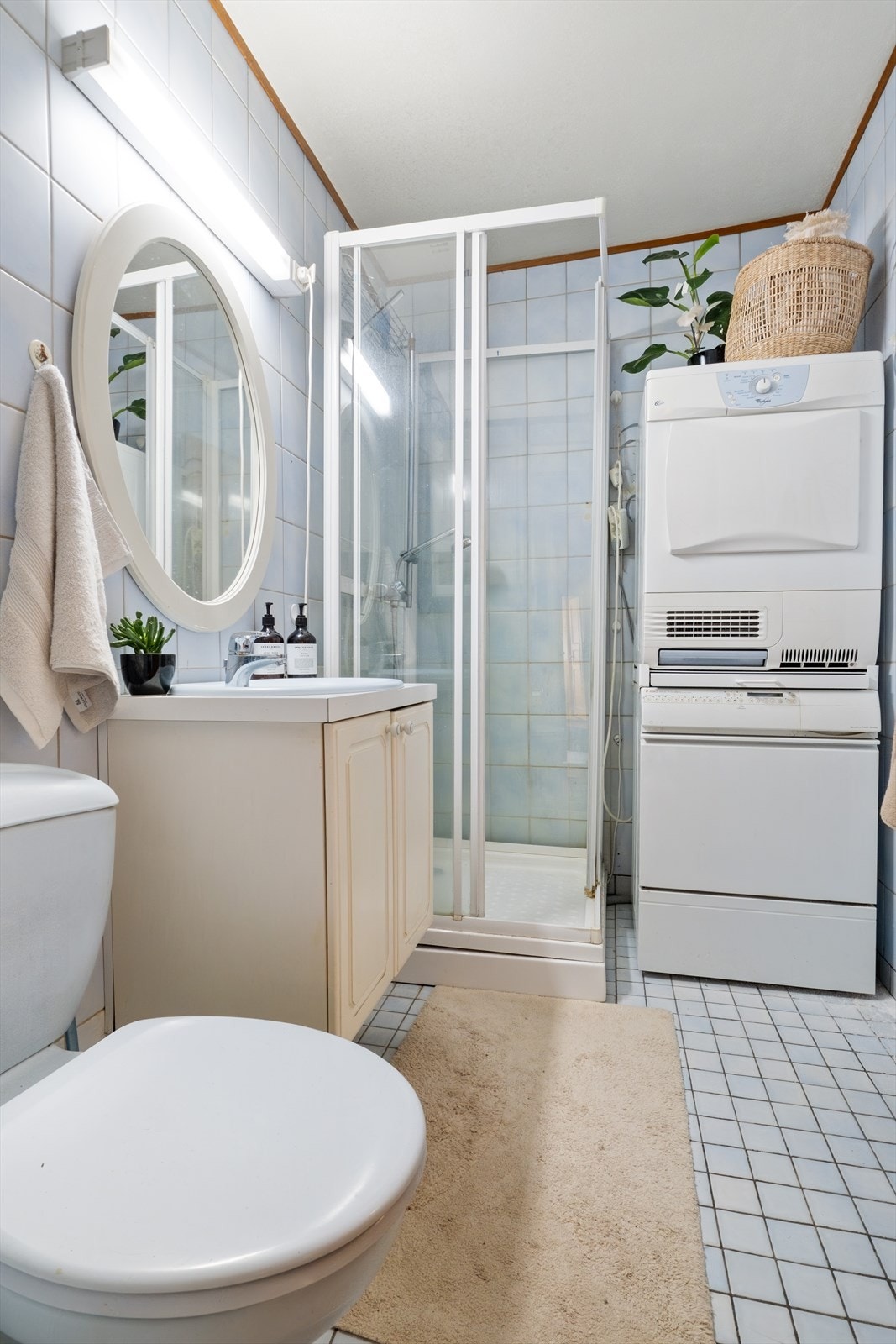 Stort flislagt baderom med eldre standard. Her finnes dusjkabinett, servant med innredning, samt opplegg for vaskemaskin. Moderniseringsbehov. Galleribilde