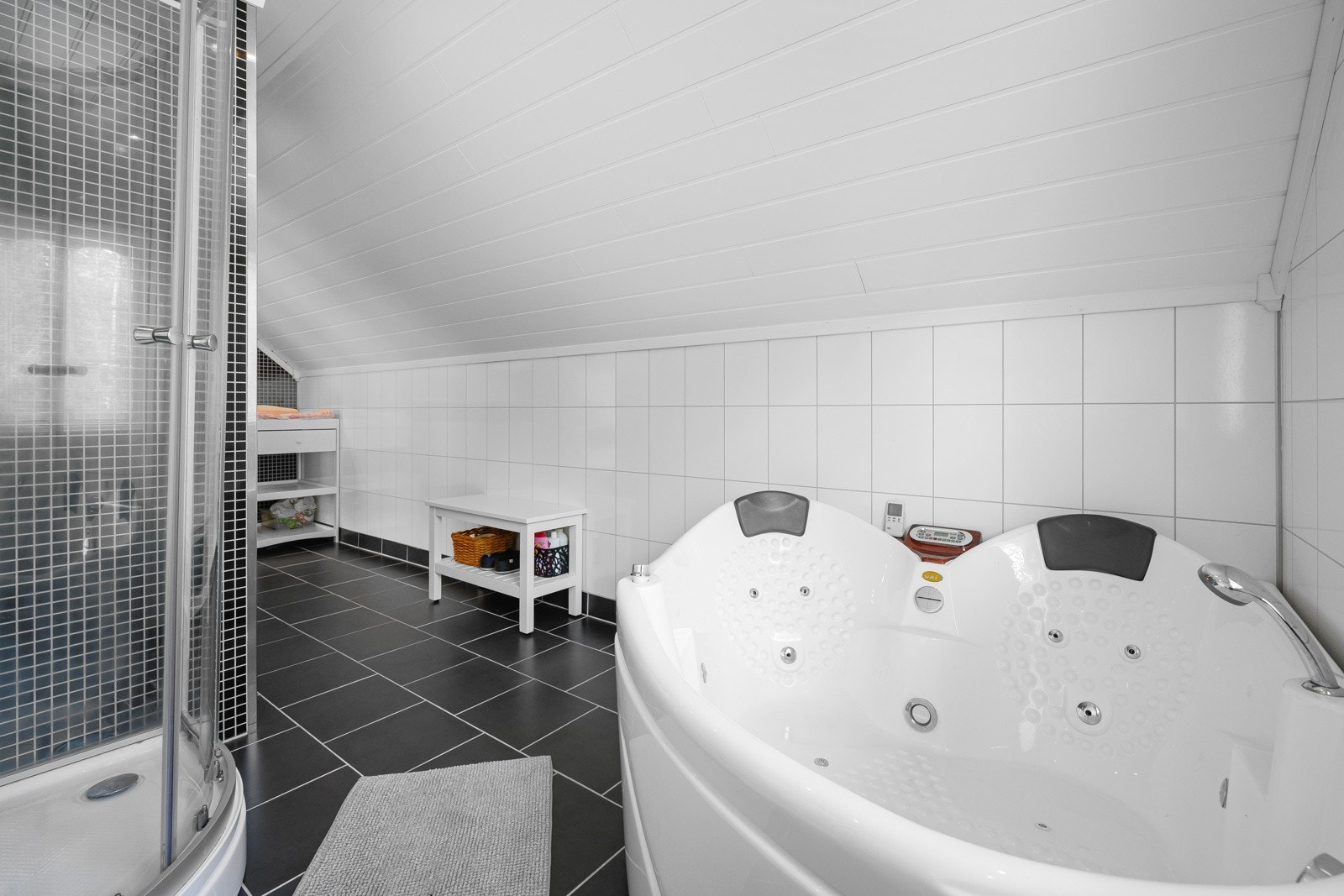 Badet har toalett, servant, dusj og hjørnekar Galleribilde