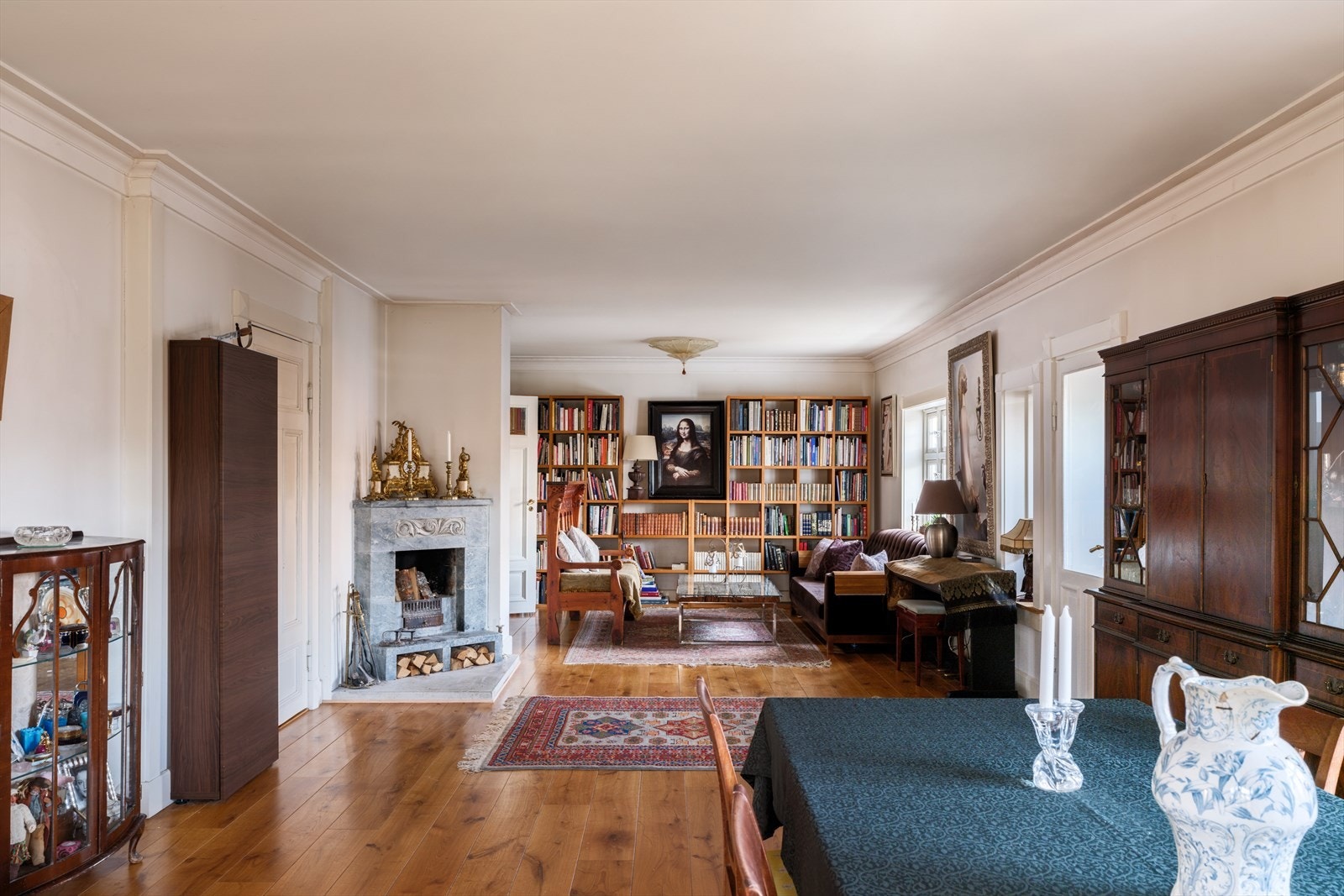 Stor stue/spisestue fra entré - Boligen har moderniseringsbehov men det er utstrakt bruk av kvalitetsmaterialer som heltre gulv, bredt listverk med ornamenter og pene, slette overflater Galleribilde