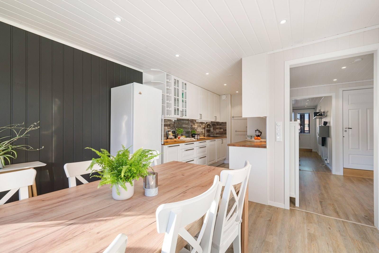 Lekkert og innbydende kjøkken i eget rom, med stilren Ikea-innredning i hvite, profilerte fronter som gir et klassisk og elegant uttrykk. Galleribilde