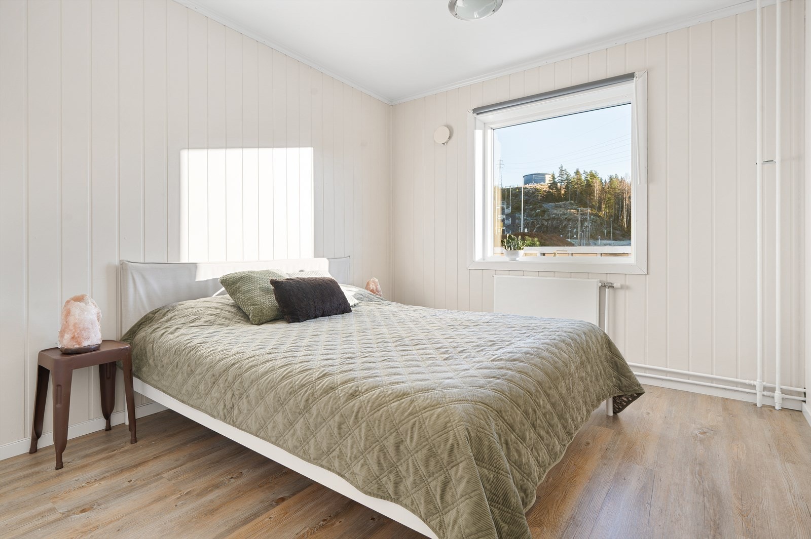 Soverom 1 har lysmalte panelplater på vegger og god plass til dobbeltseng med tilhørende møblement. Galleribilde