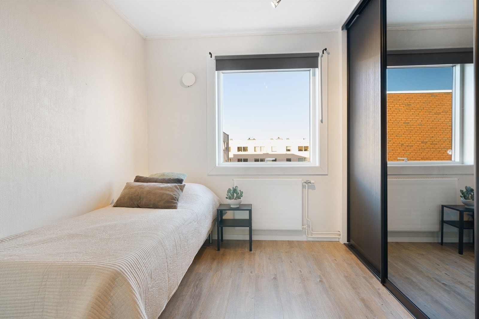 Soverom 2 har en romslig skyvedørsgarderobe i moderne sort og praktiske speilfronter. Galleribilde