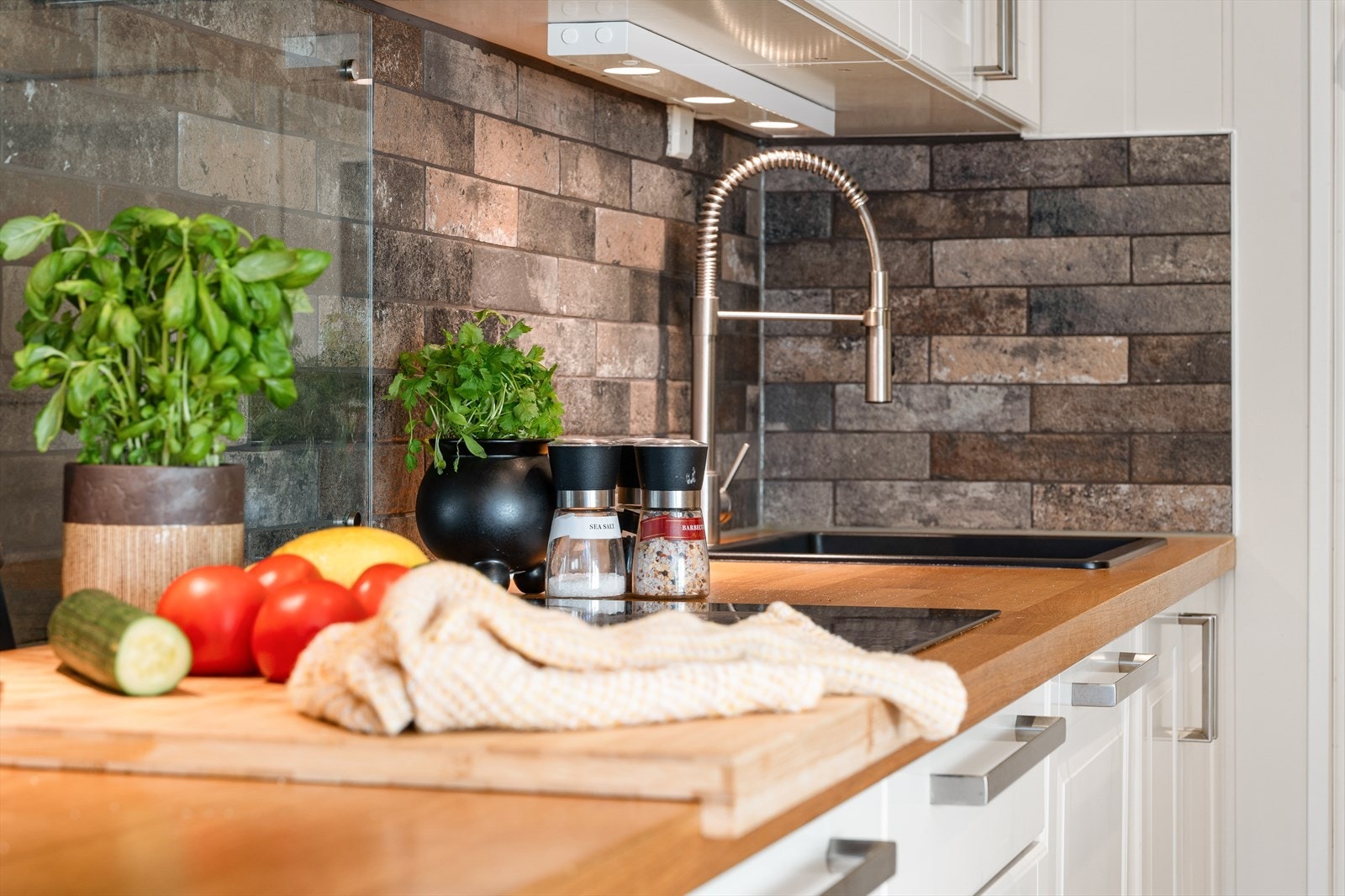 Den solide heltre benkeplaten gir rommet varme og et eksklusivt preg, og står i flott kontrast til den moderne, sorte komposittvasken med tilhørende sort armatur. Galleribilde