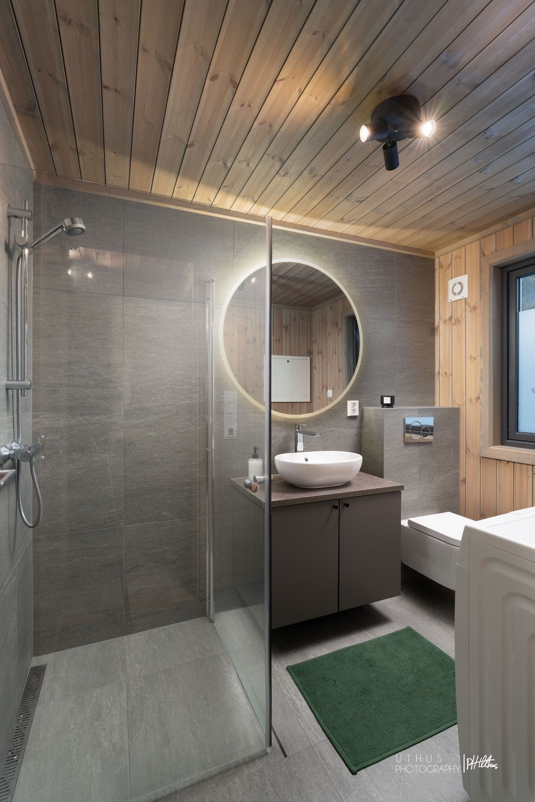 Bad fra byggeår med flislagt gulv, dusjhjørne og opplegg for vaskemaskin. Galleribilde