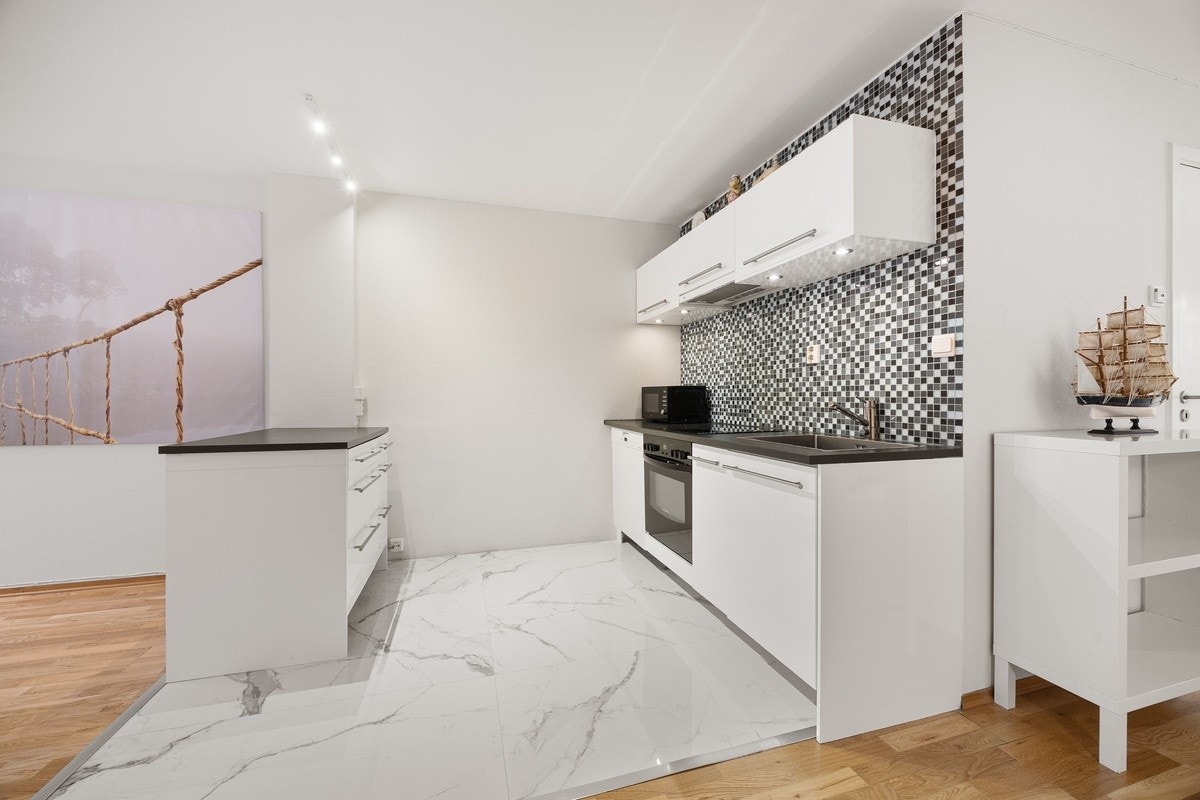 Praktisk kjøkken med integrerte hvitevarer og god benkeplass Galleribilde