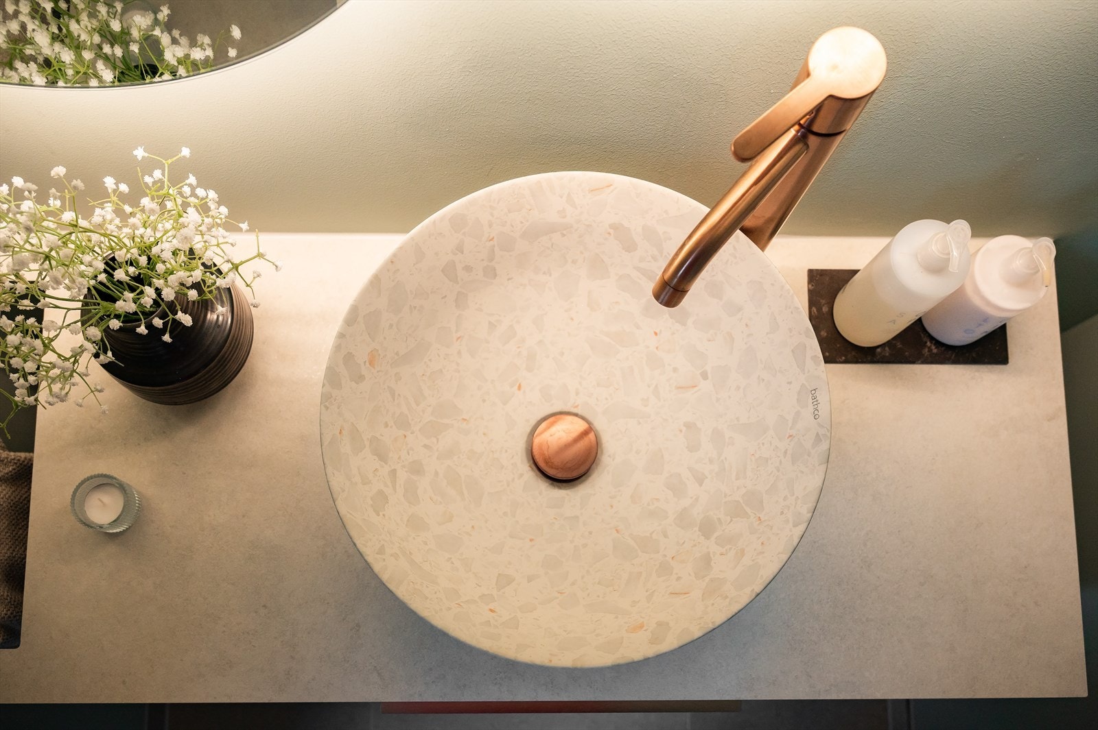 Badet har BIG servantskap i taupe med benkeplate i beige og integrert håndkleholder, kombinert med en bolleservant i terrazzo. Galleribilde