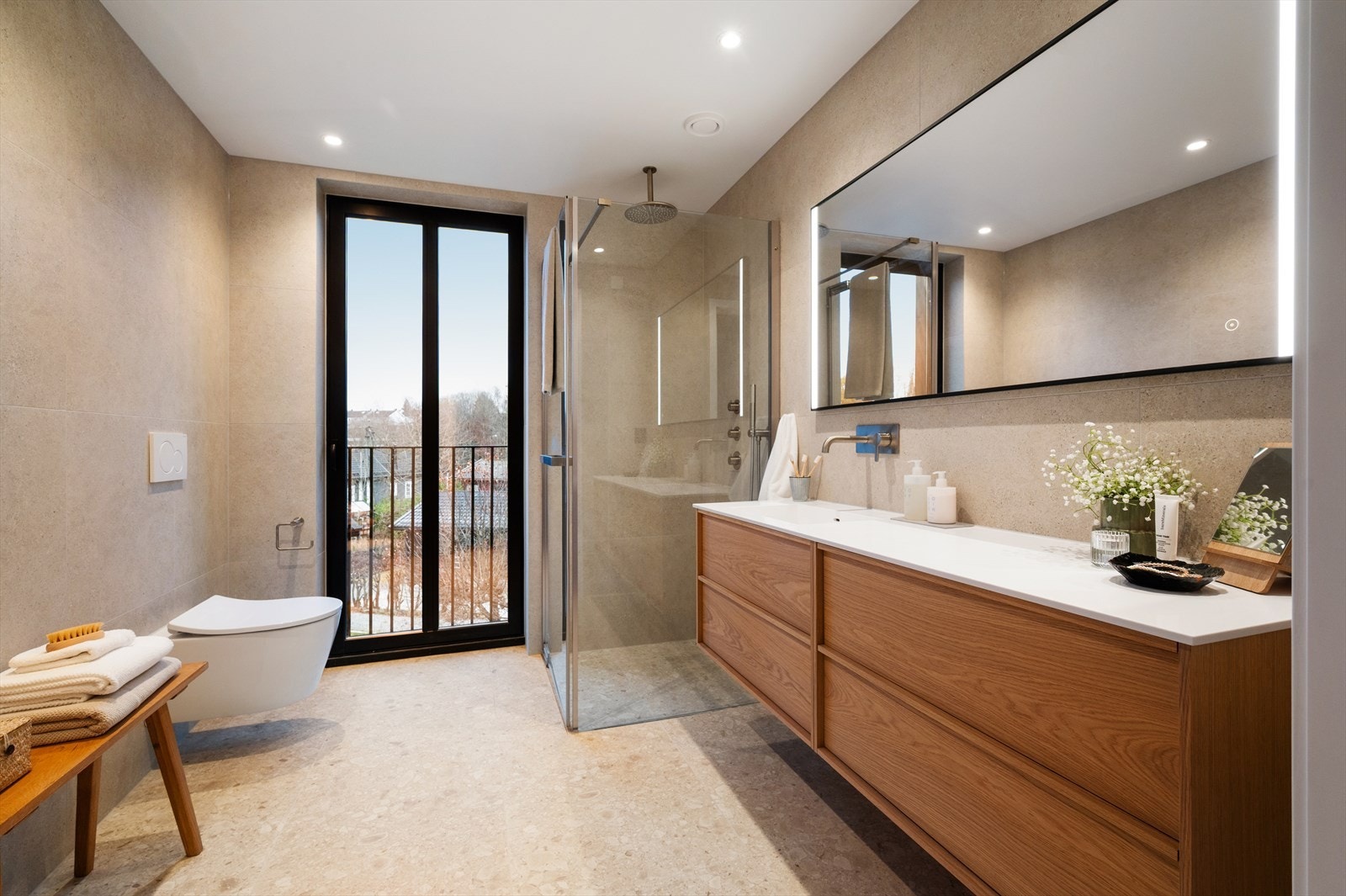 Et eksklusivt og romslig hovedbad med påkostede løsninger. Gulvet er belagt med store fliser i Pro Flodsten Arctic 60x60, mens veggene er kledd i Pro Kalksten Arctic 60x60 for et helhetlig og elegant uttrykk. Galleribilde