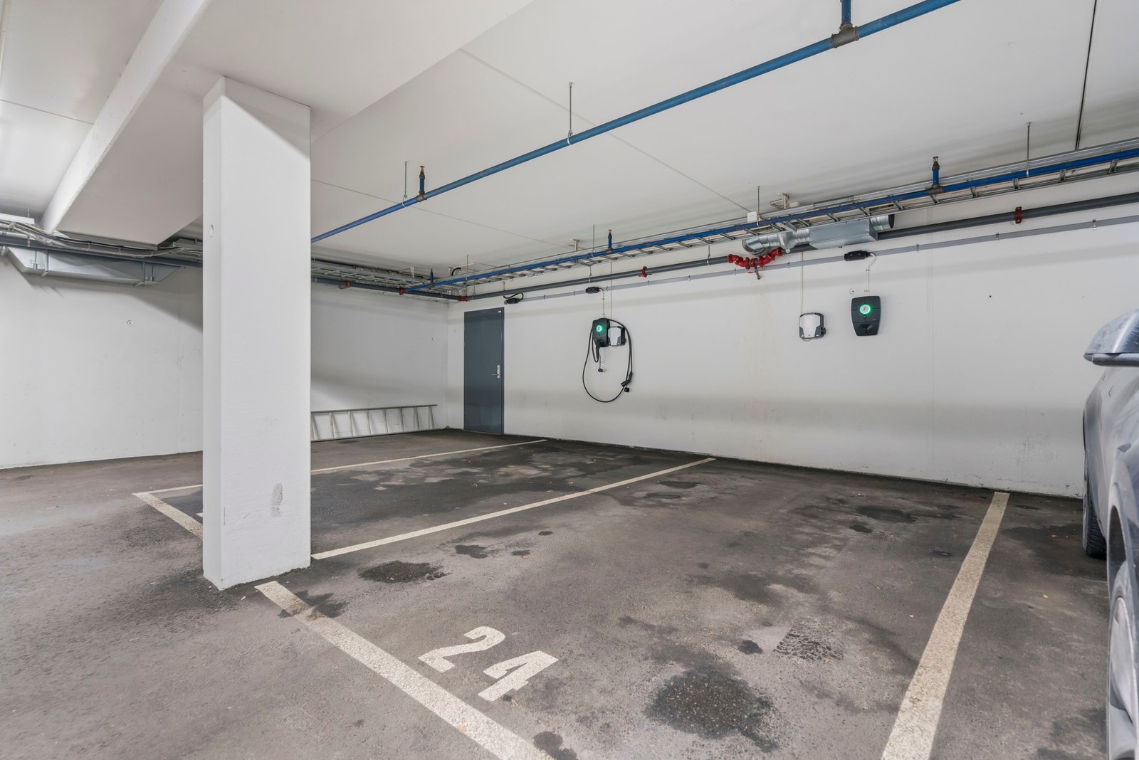 Det er el-bil lader på plassen i samme bygg. Boligen disponerer to parkeringsplasser, hvorav én er i garasjekjeller med elbillader og heis helt opp til etasjeplan. Den andre plassen ligger i nabobygget og leies ut pr. i dag Galleribilde