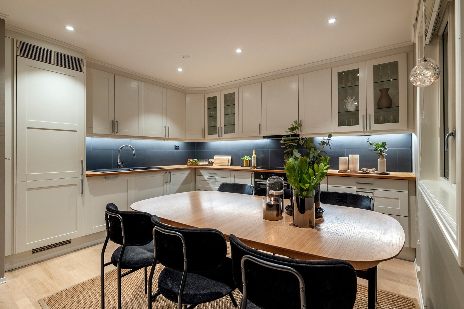 Kjøkkeninnredningen har lyse fronter kombinert med glassfelt i enkelte overskap, samt heltre benkeplater med nedfelt oppvaskkum i kompositt. Galleribilde