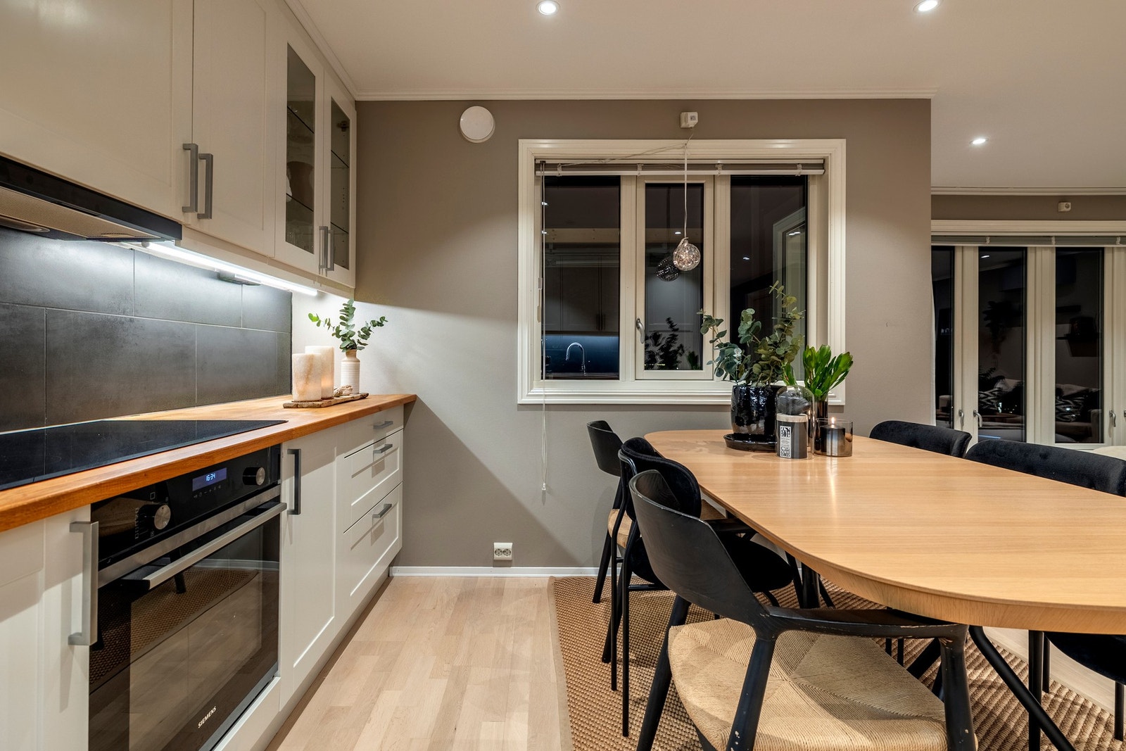 Kjøkkenet er utstyrt med integrerte hvitevarer som induksjonstopp, komfyr, oppvaskmaskin og kjøleskap med frysedel. Galleribilde