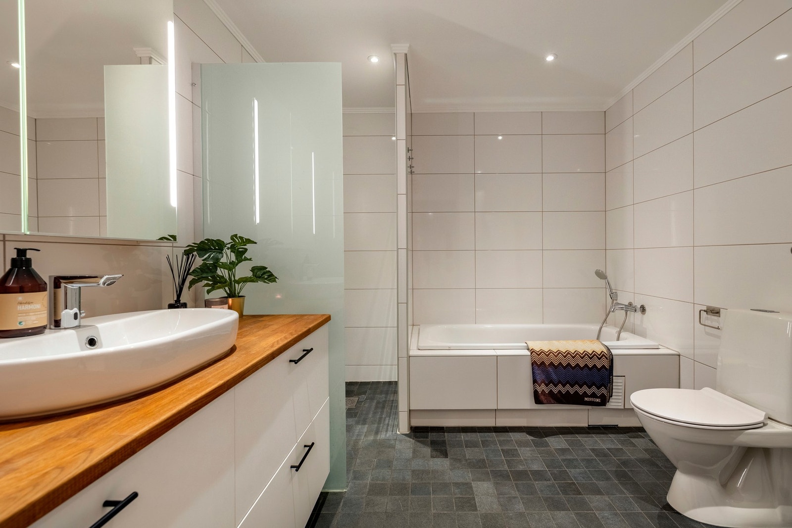 Badet har flislagte vegger- og gulv, varmekabler og innfelt downlights. Galleribilde