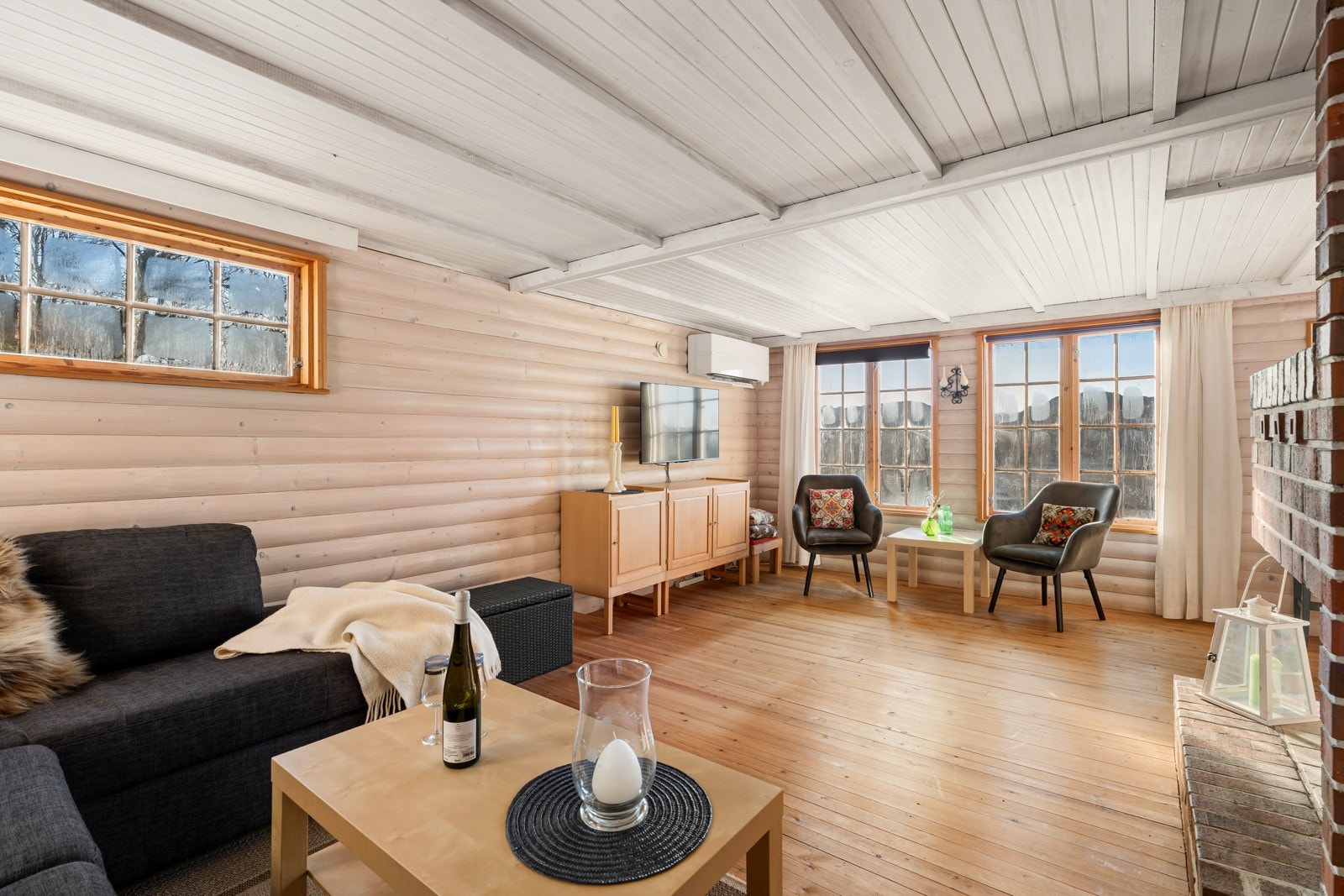 Stuen er et hyggelig oppholdsrom med furgulv, tømmervegger og god møbleringsfrihet i vinkelløsning. Galleribilde