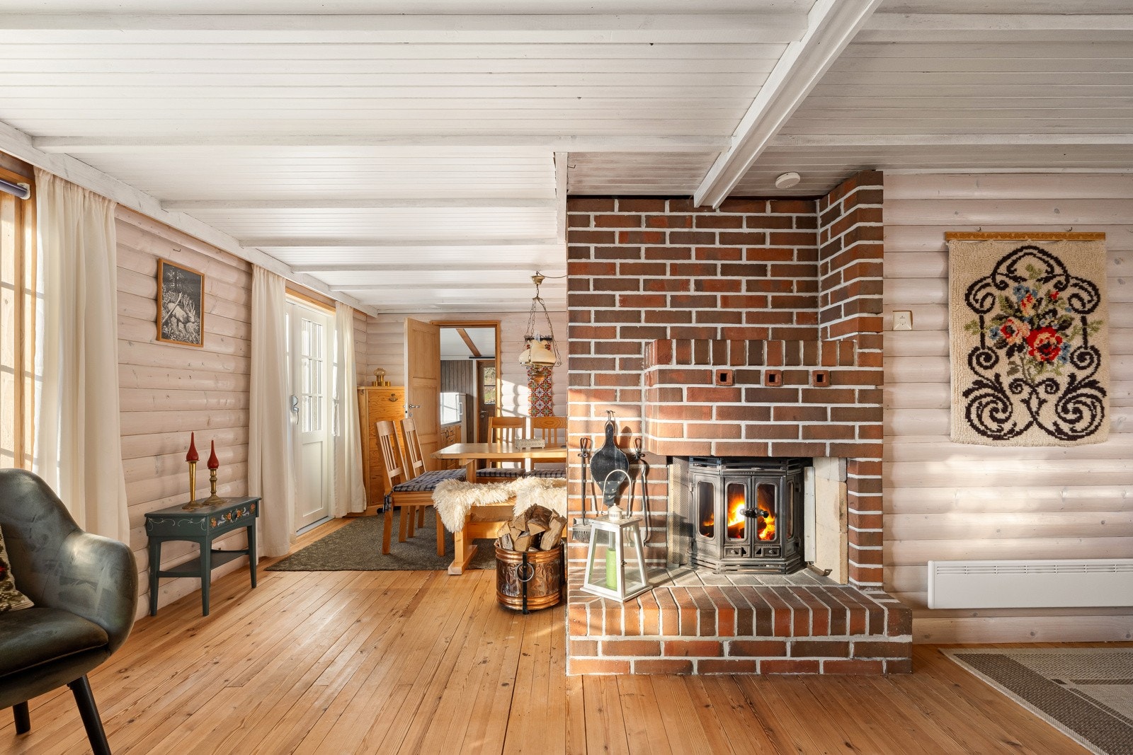 Med både oppmurt peis og nyere varmepumpe får man det lunt og godt i stuen - og lite slår avslappende vinterkvelder foran peisen. Galleribilde